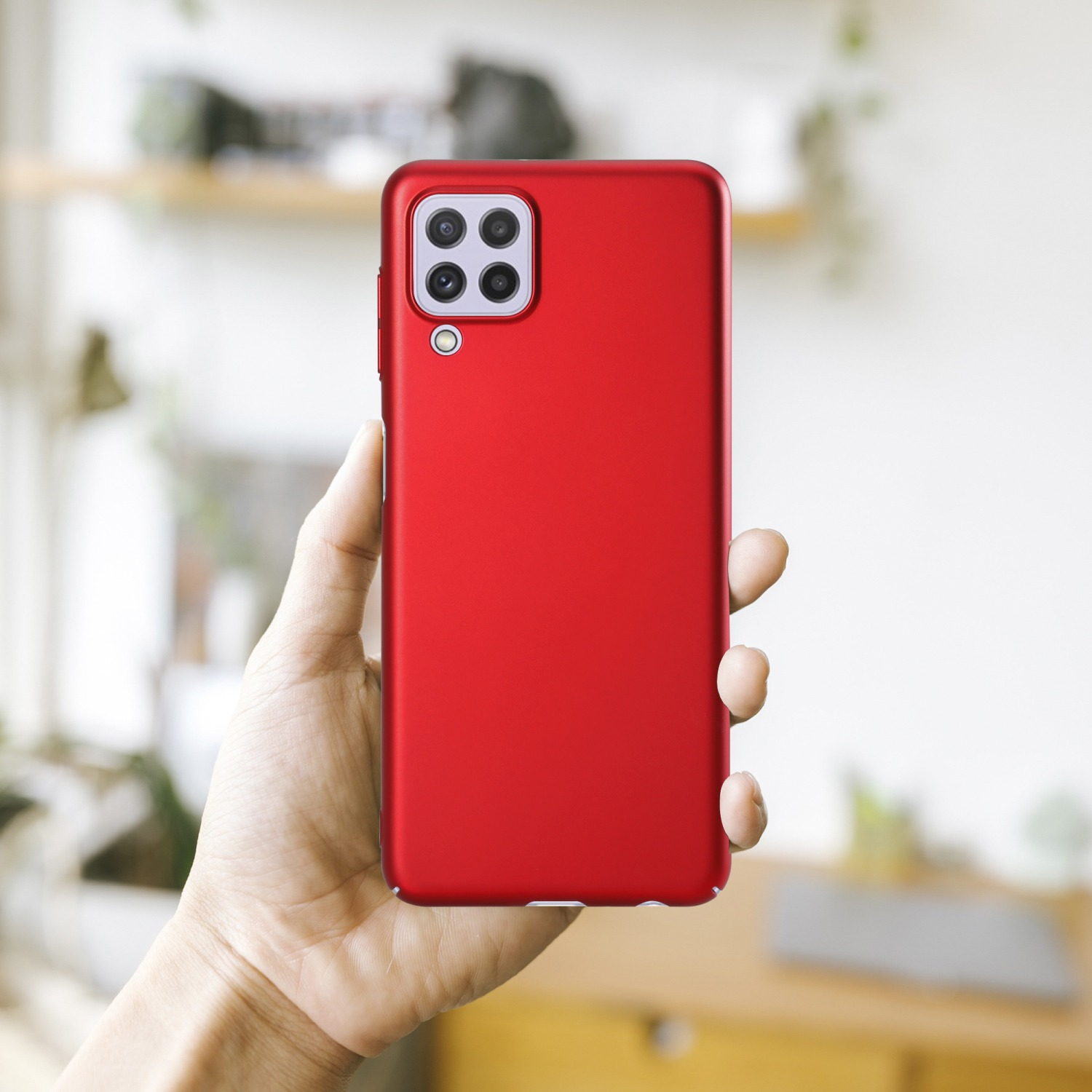 Eine rote Handyhülle in einer Hand. Der Hintergrund ist unscharf.