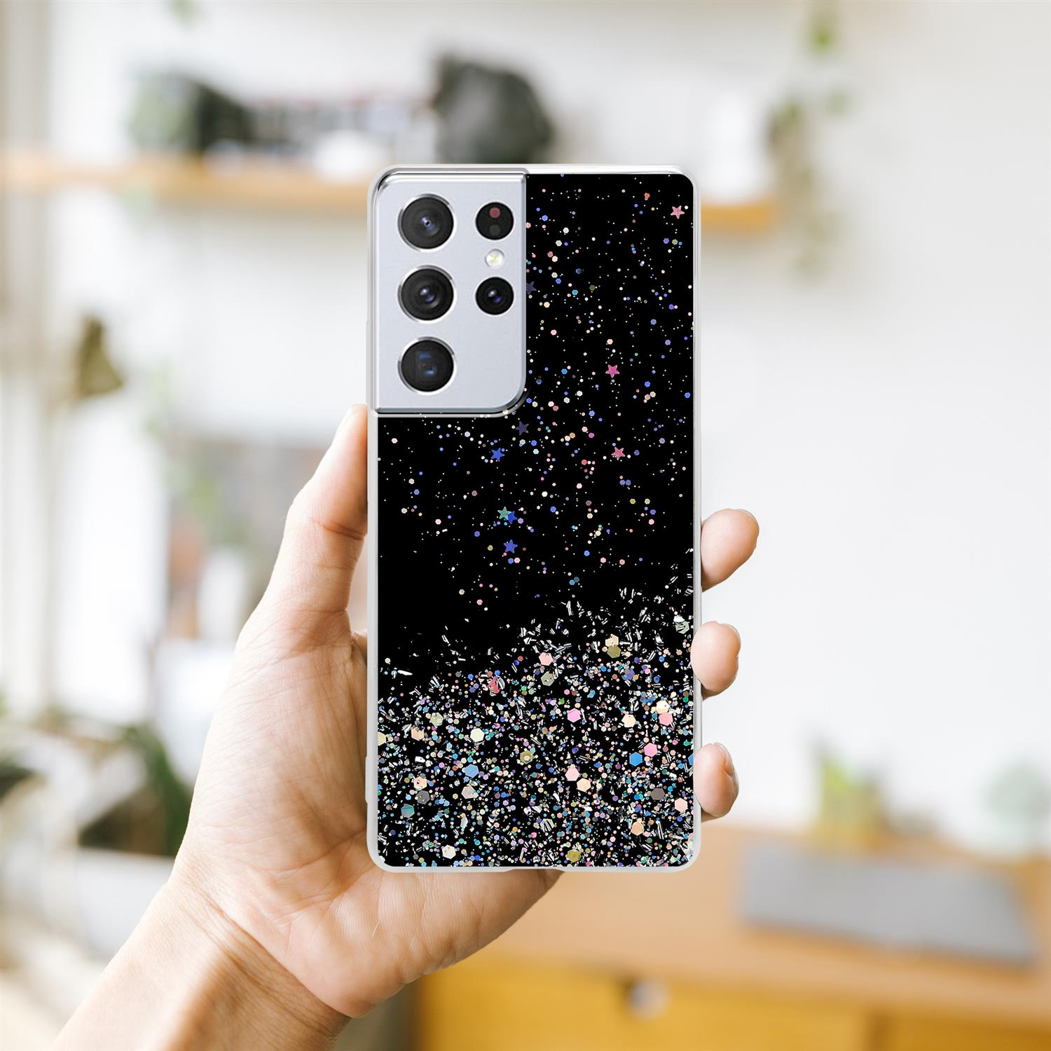 Una custodia per telefono con un design glitterato nero. Una mano tiene il telefono, mostrando il retro.