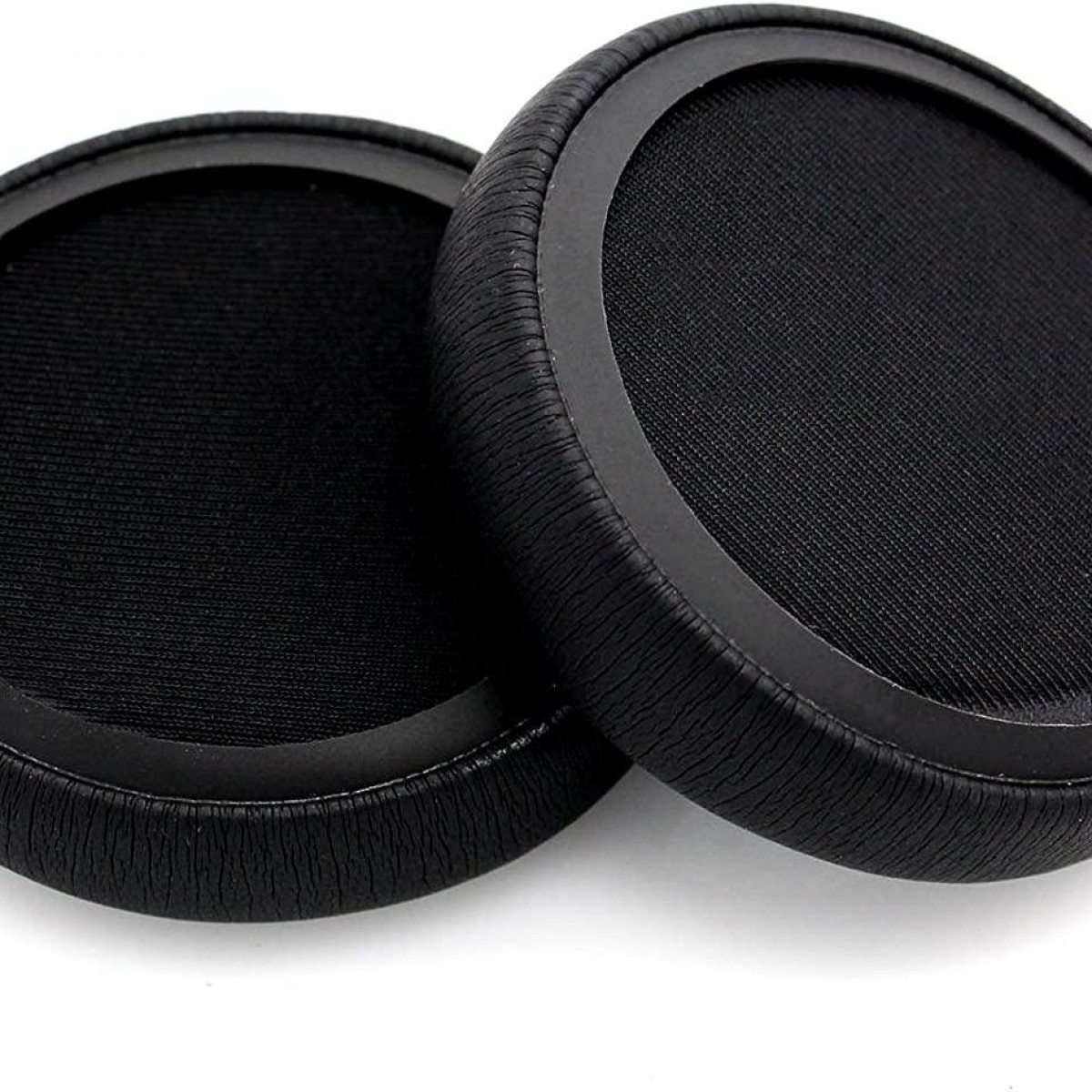 Dwie czarne nausznice do słuchawek, zbliżenie, z czarną powierzchnią z tkaniny i ciemną obwódką.