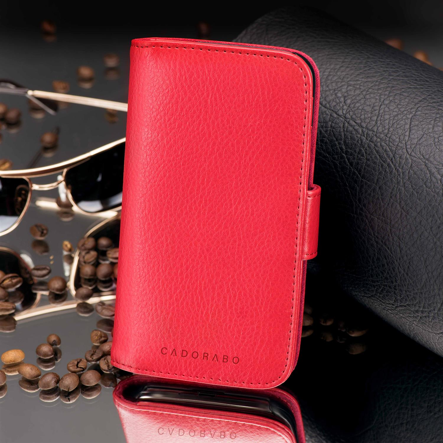 Una custodia per telefono in pelle rossa con una cornice dorata e un riflesso di occhiali da sole e chicchi di caffè.