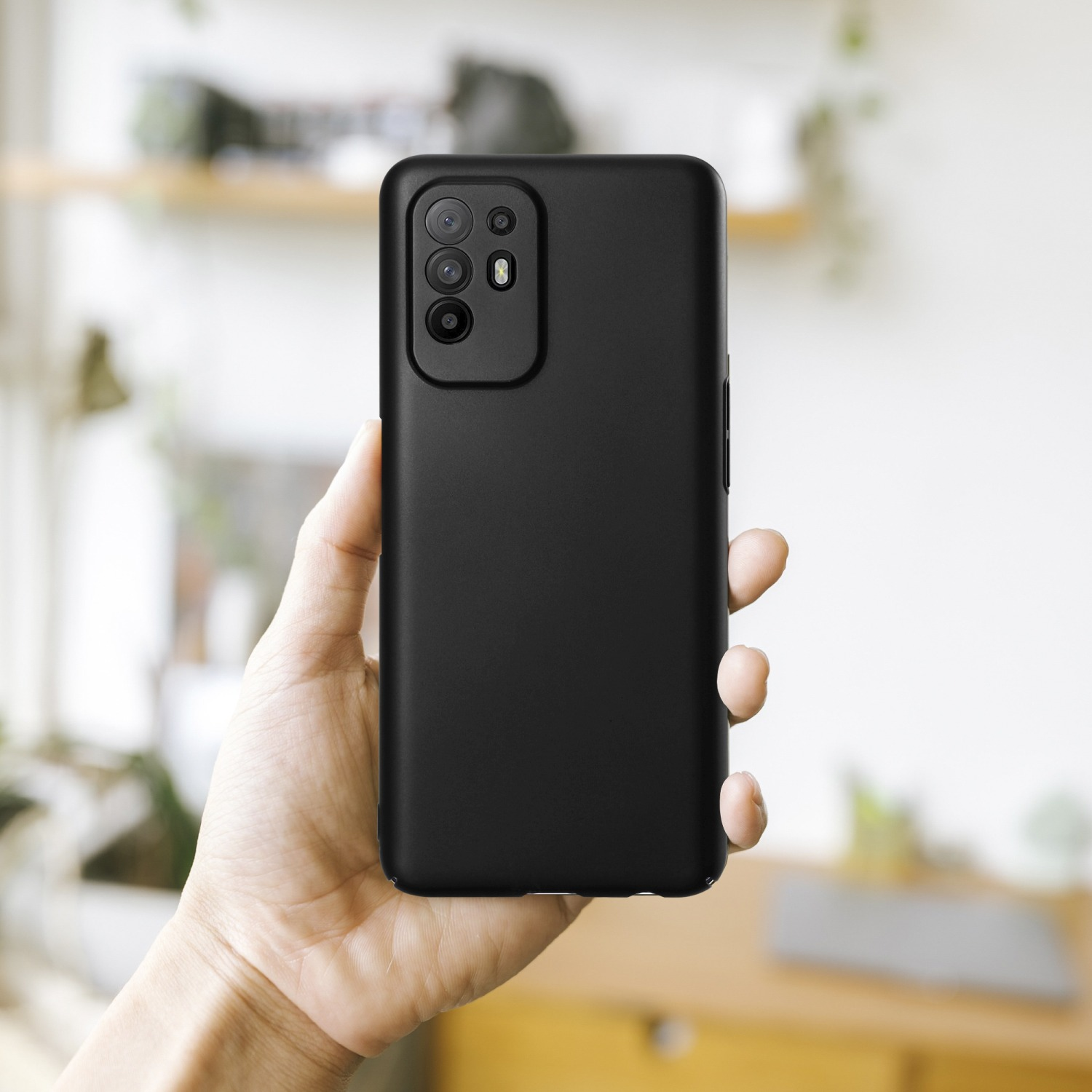 Schwarze Handyhülle in der Hand, zeigt die Rückseite des Telefons mit Kamera.
