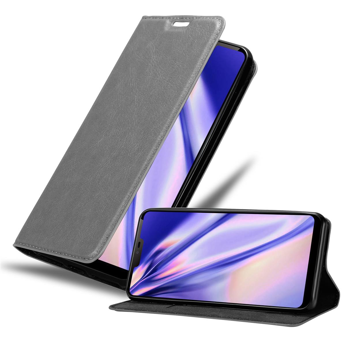 Eine graue Handyhülle mit einem Telefon darin. Das Telefon steht auf einem Ständer. Der Koffer ist offen.