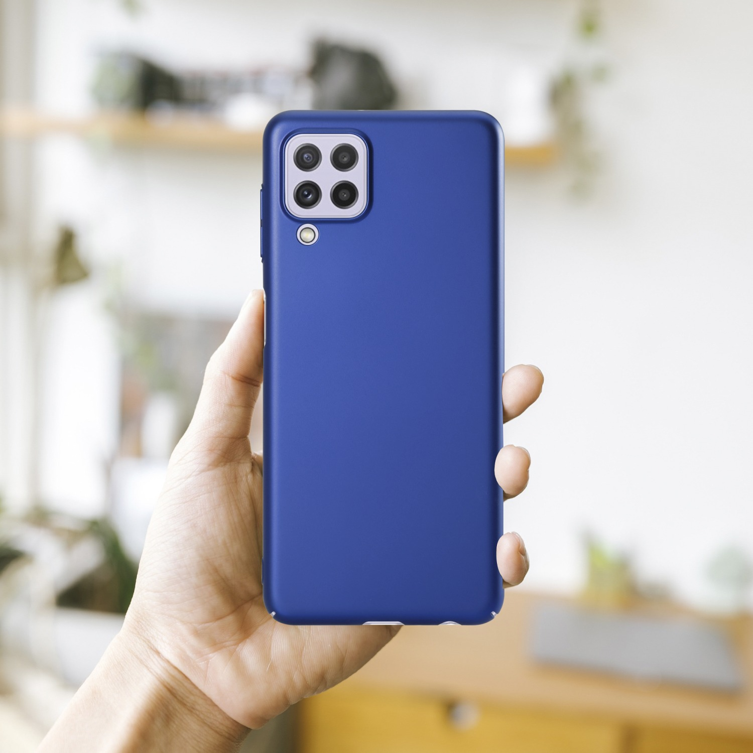 Eine Hand hält eine blaue Handyhülle mit Kameramodul auf der Rückseite.