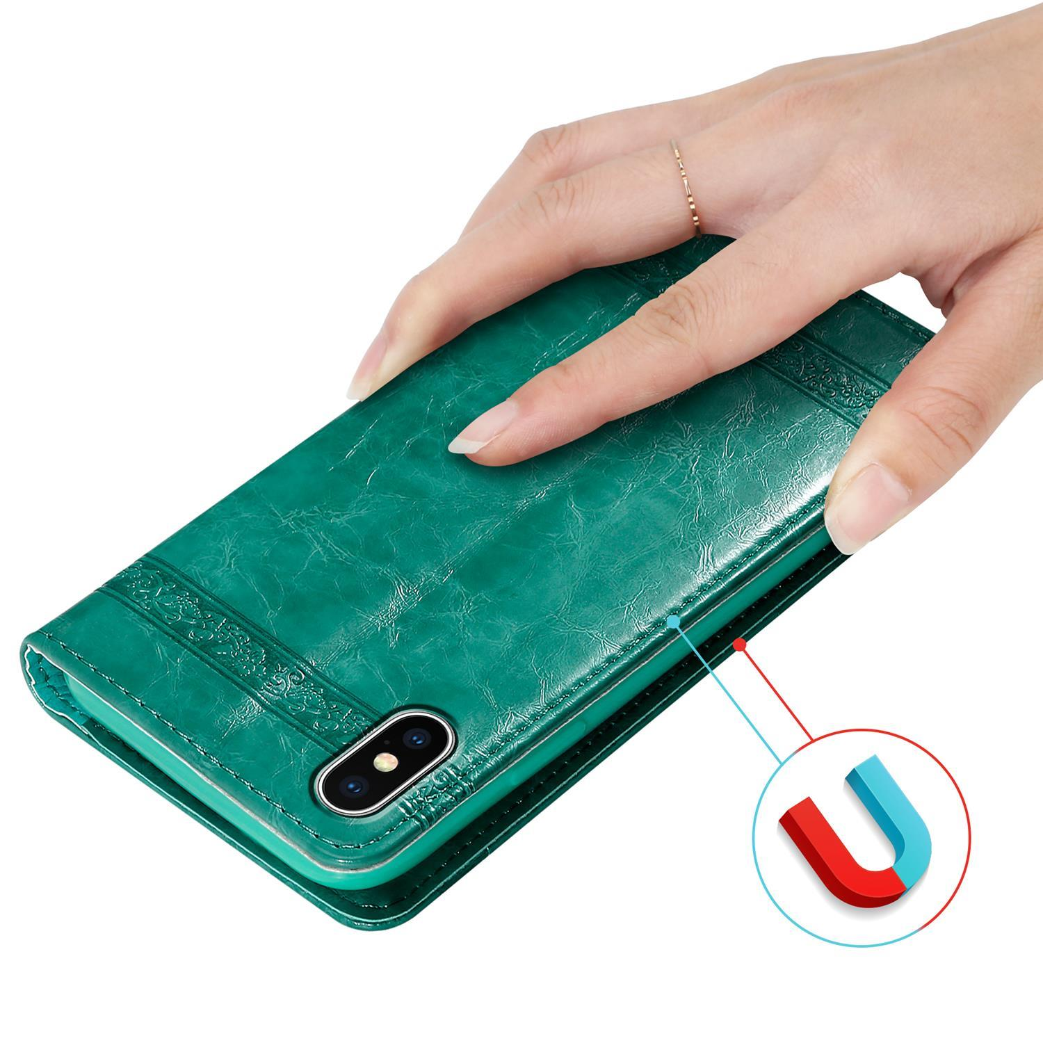 Hand hält teal Handyhülle. Rote und blaue Magnete neben der Hülle. Ring am Finger.