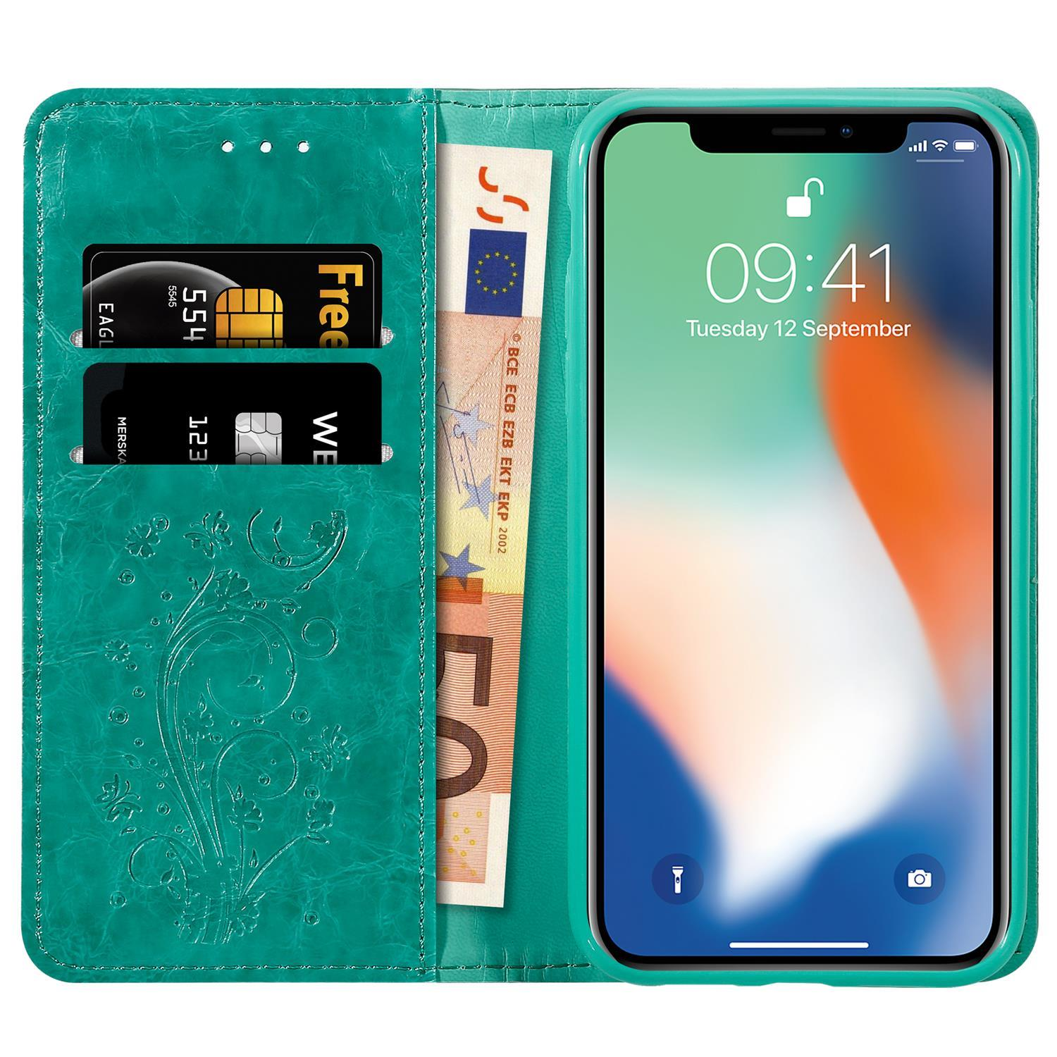 Eine türkisblaue Handyhülle, die geöffnet ist und ein Telefon, Karten und Bargeld zeigt.