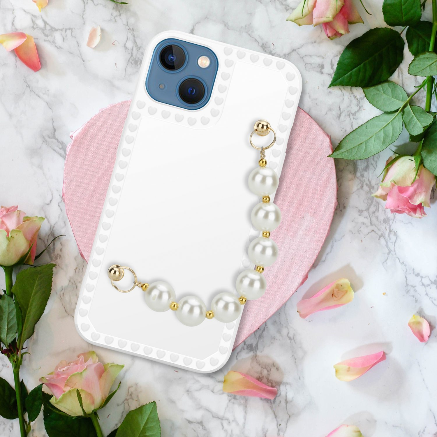 Weisse Handyhülle mit Perlenkette. Blumen und rosa herzförmiger Hintergrund.