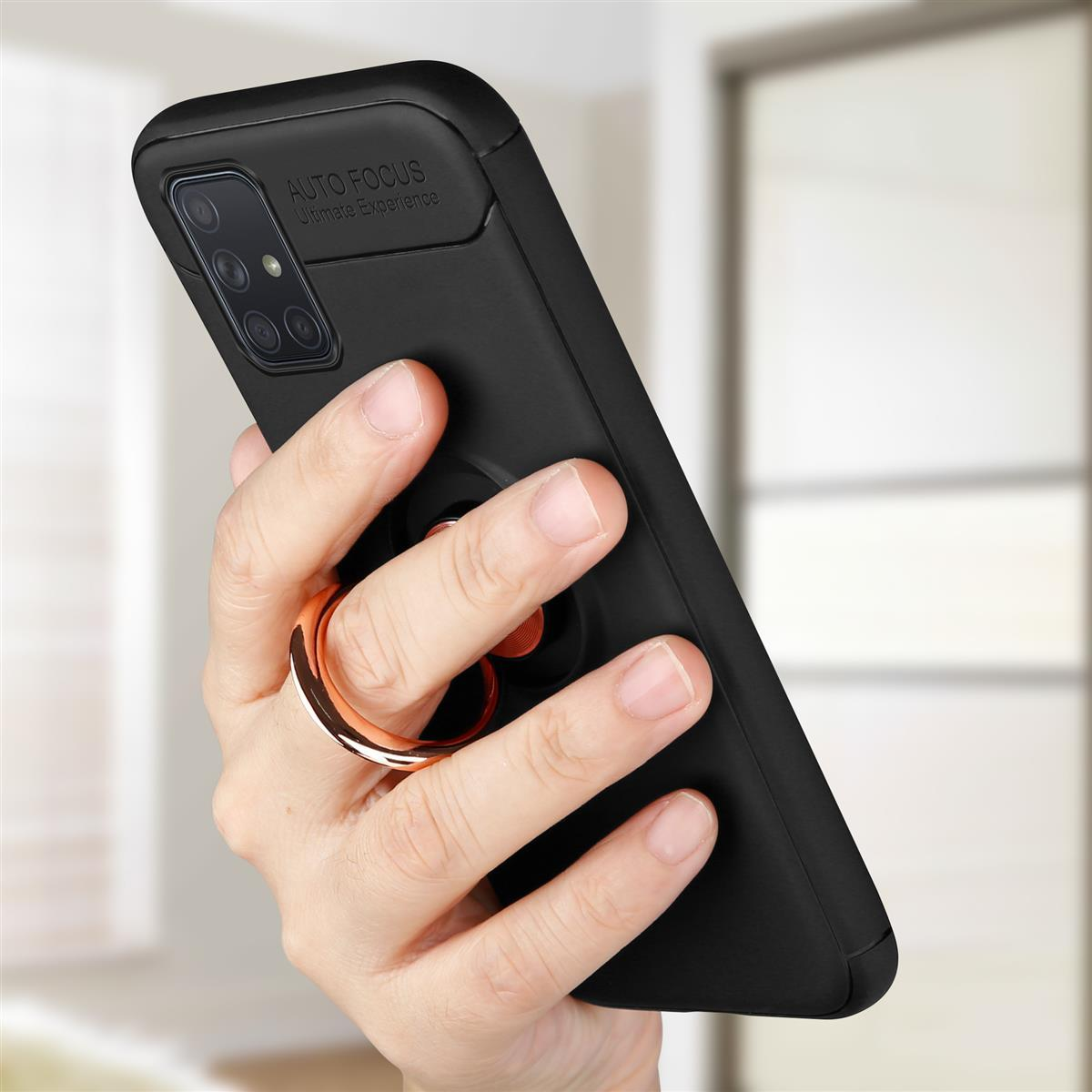 Hand hält eine schwarze Handyhülle mit goldenem Ring. Die Handyhülle hat einen Autofokus-Text.