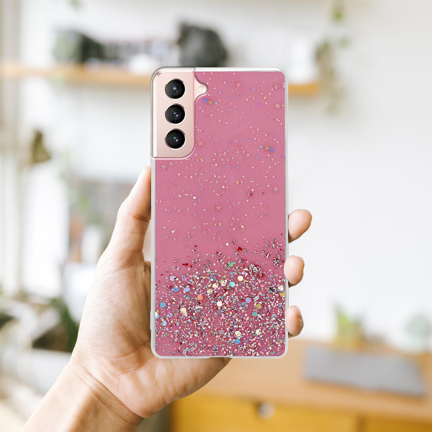 Eine Hand hält eine rosa Handyhülle mit Glitzer- und Sterndesign.