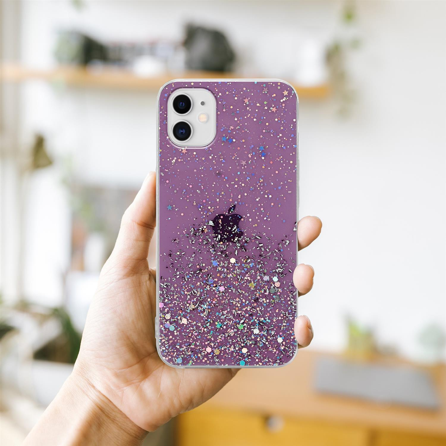Hand hält glitzernde lila Handyhülle mit Telefon darin.