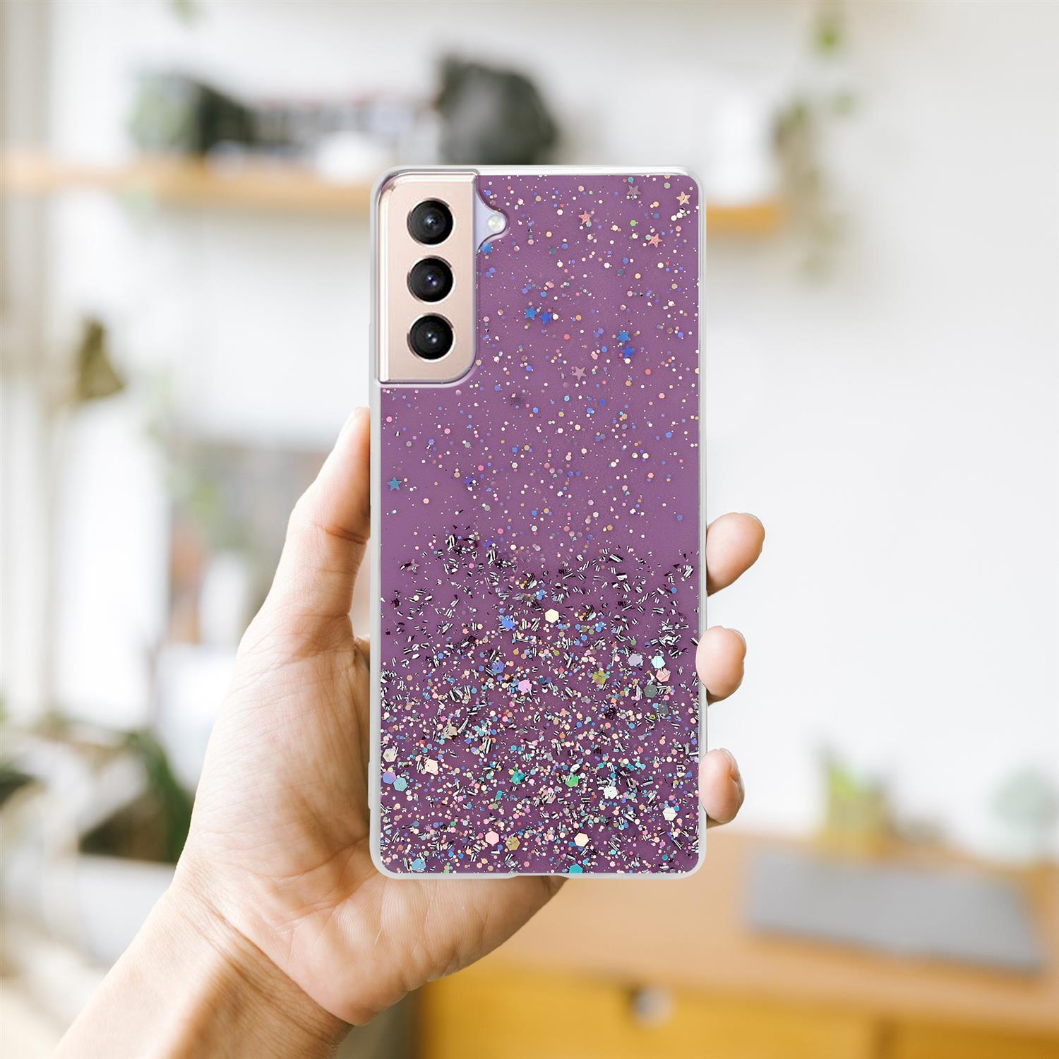 Lila Handyhülle mit Glitzer. Eine Hand hält das Telefon. Ein Ausschnitt zeigt den Glitzer.