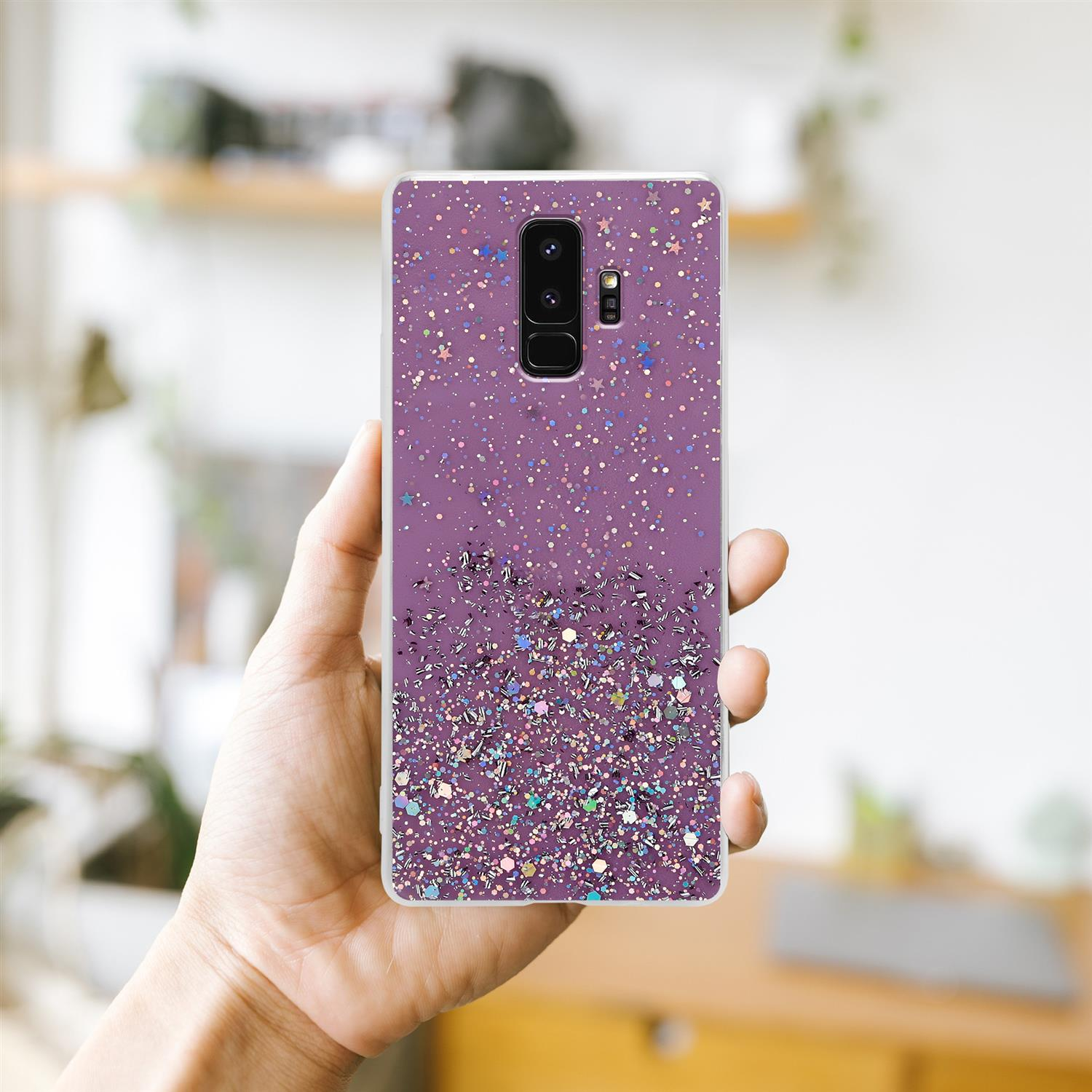 Hand hält eine lila Handyhülle mit Glitzer. Hülle hat Kamera- und Blitzlöcher.