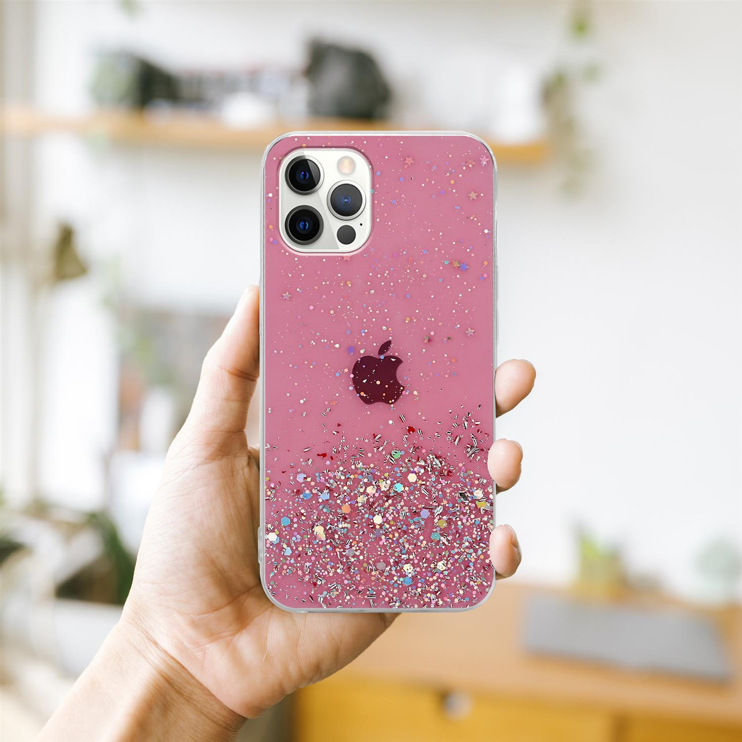 Rosa Handyhülle mit Glitzer, gehalten von einer Hand. Hintergrund: ein Regal mit Gegenständen.