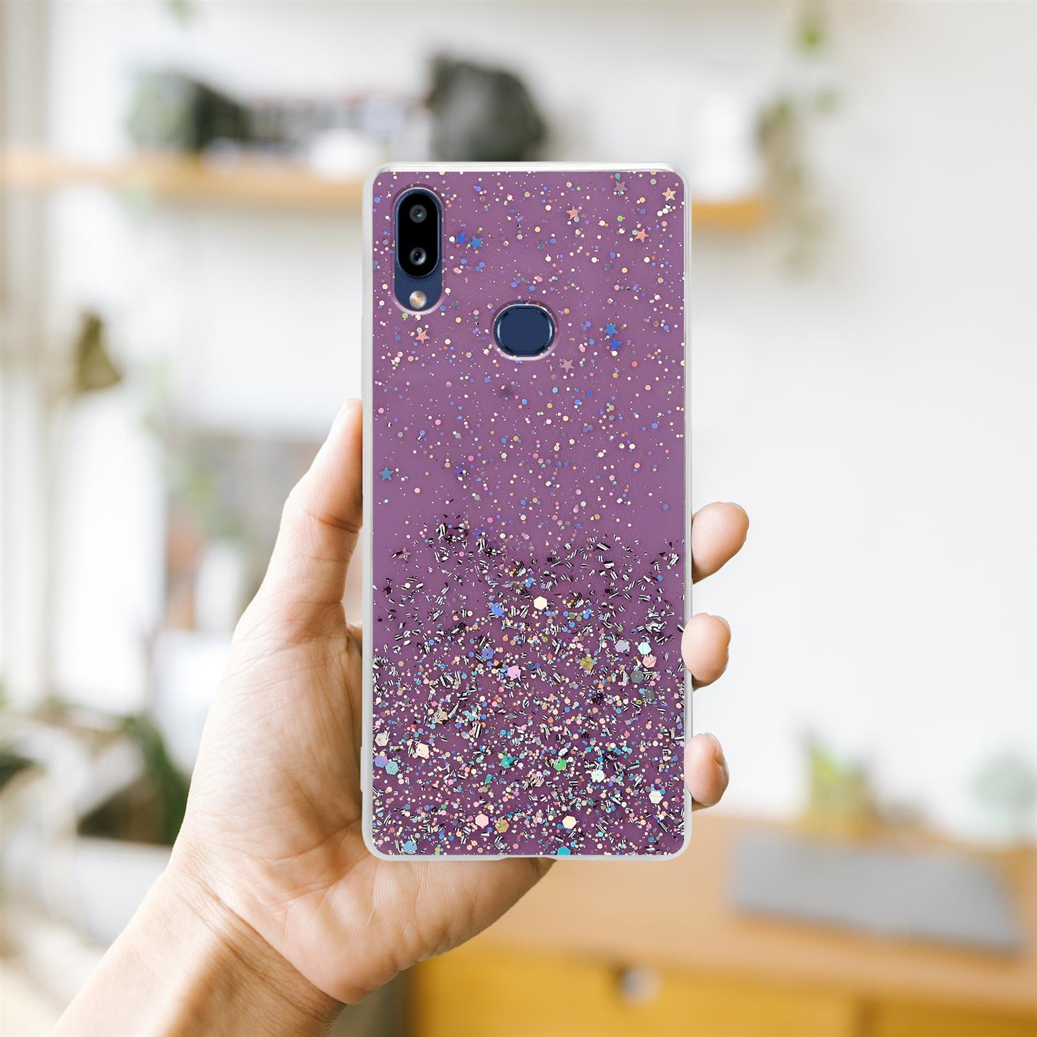 Lila Handyhülle mit Glitzer. Hand hält Telefon, unscharfer Hintergrund.