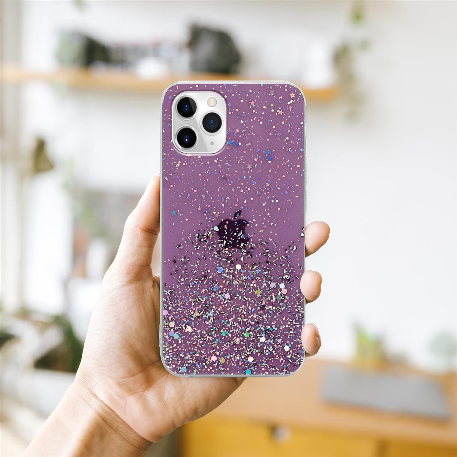 Eine Hand, die eine lila Handyhülle mit Glitzer hält. Der Hintergrund ist unscharf.