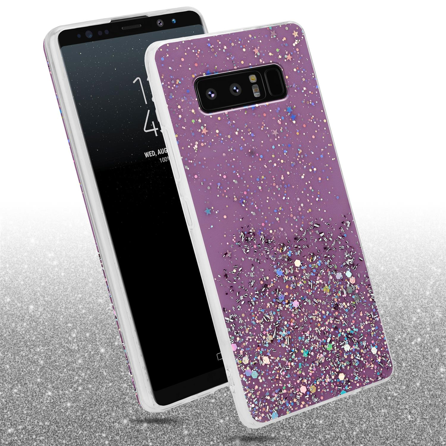Eine Handyhülle mit Glitzer in Lila und ein Telefon darin. Der Hintergrund ist glitzernd.