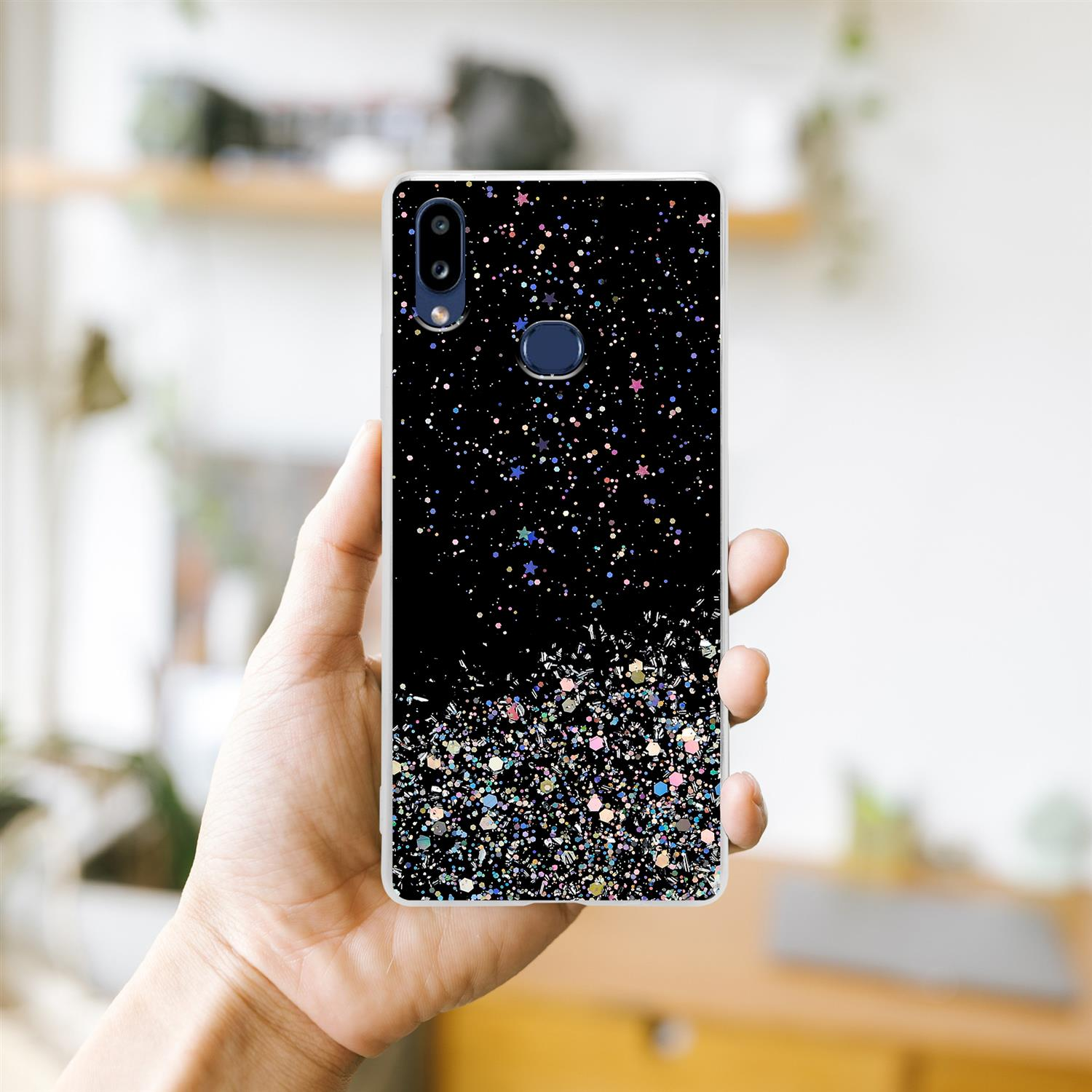 Hand hält ein Telefon mit schwarzer Hülle, bedeckt mit schillerndem Glitzer.
