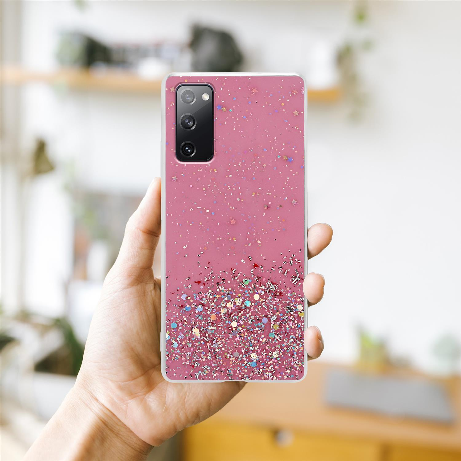 Rosa Handyhülle mit Glitzer und Sternen, gehalten von einer Hand.