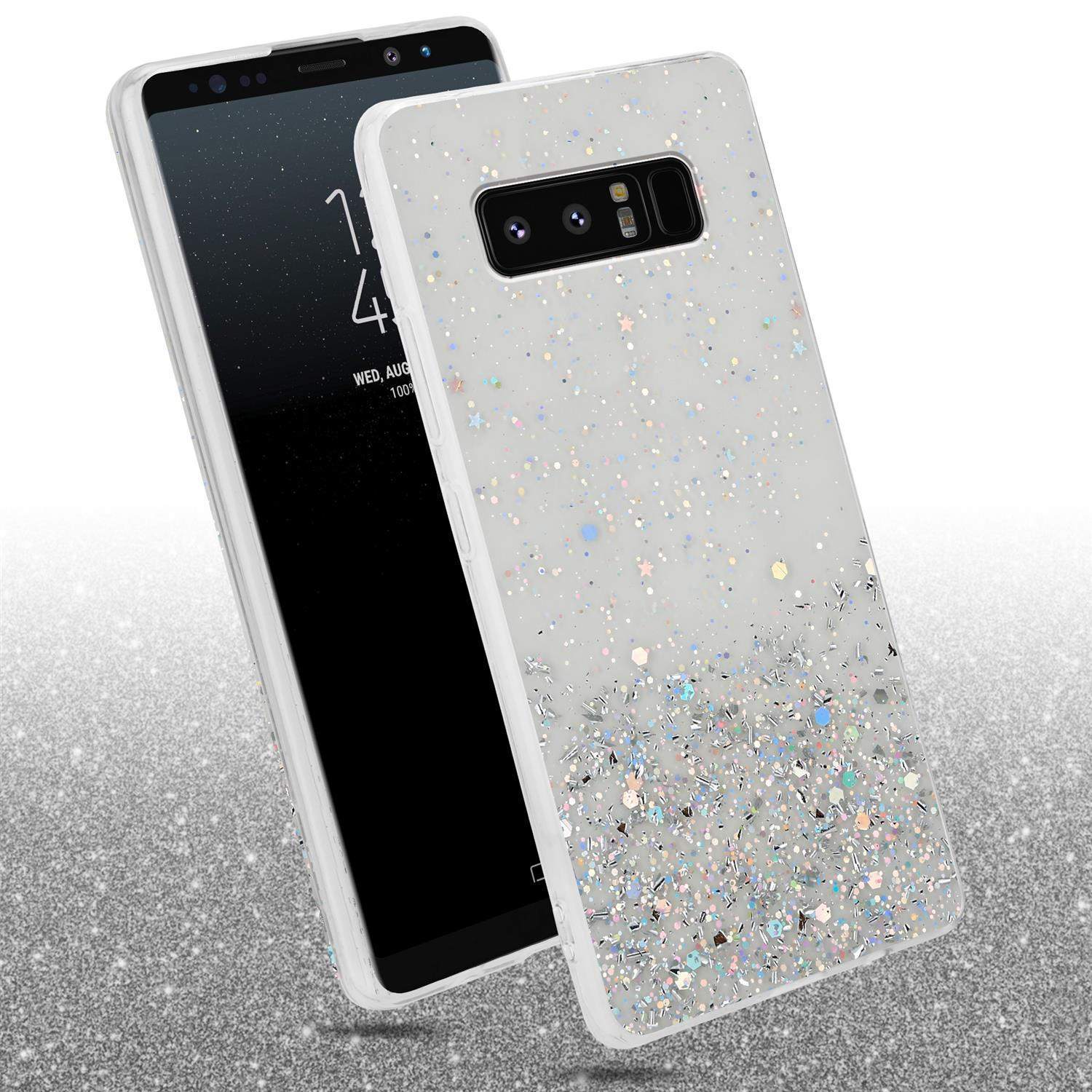 Weiße Handyhülle mit Glitzer. Ein Telefon wird schräg gehalten. Glitzernder Hintergrund mit Telefon sichtbar.