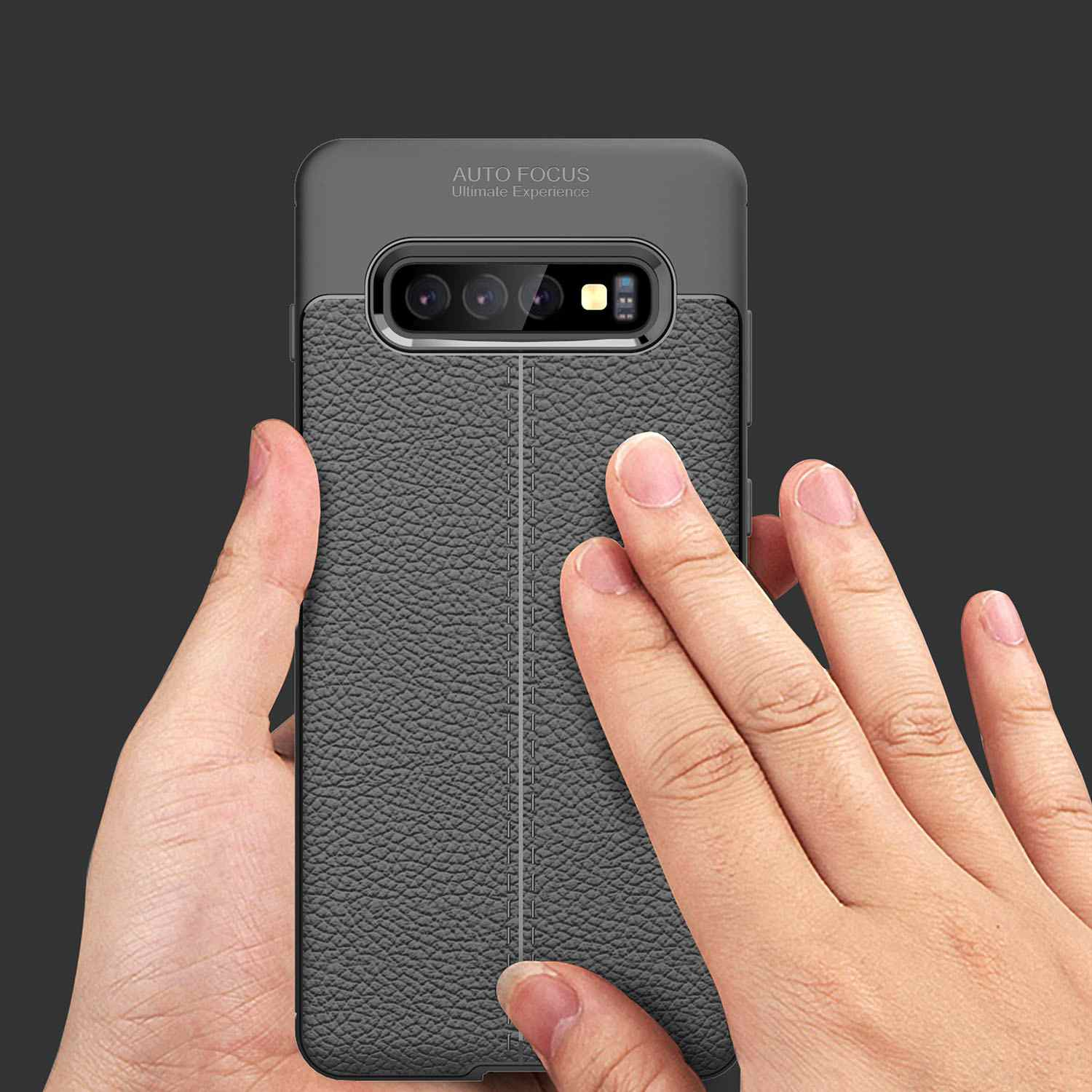 Hand hält graue, lederartige Handyhülle. Das Telefon ist grau und schwarz. Fokus auf Rückseite und Kamera.