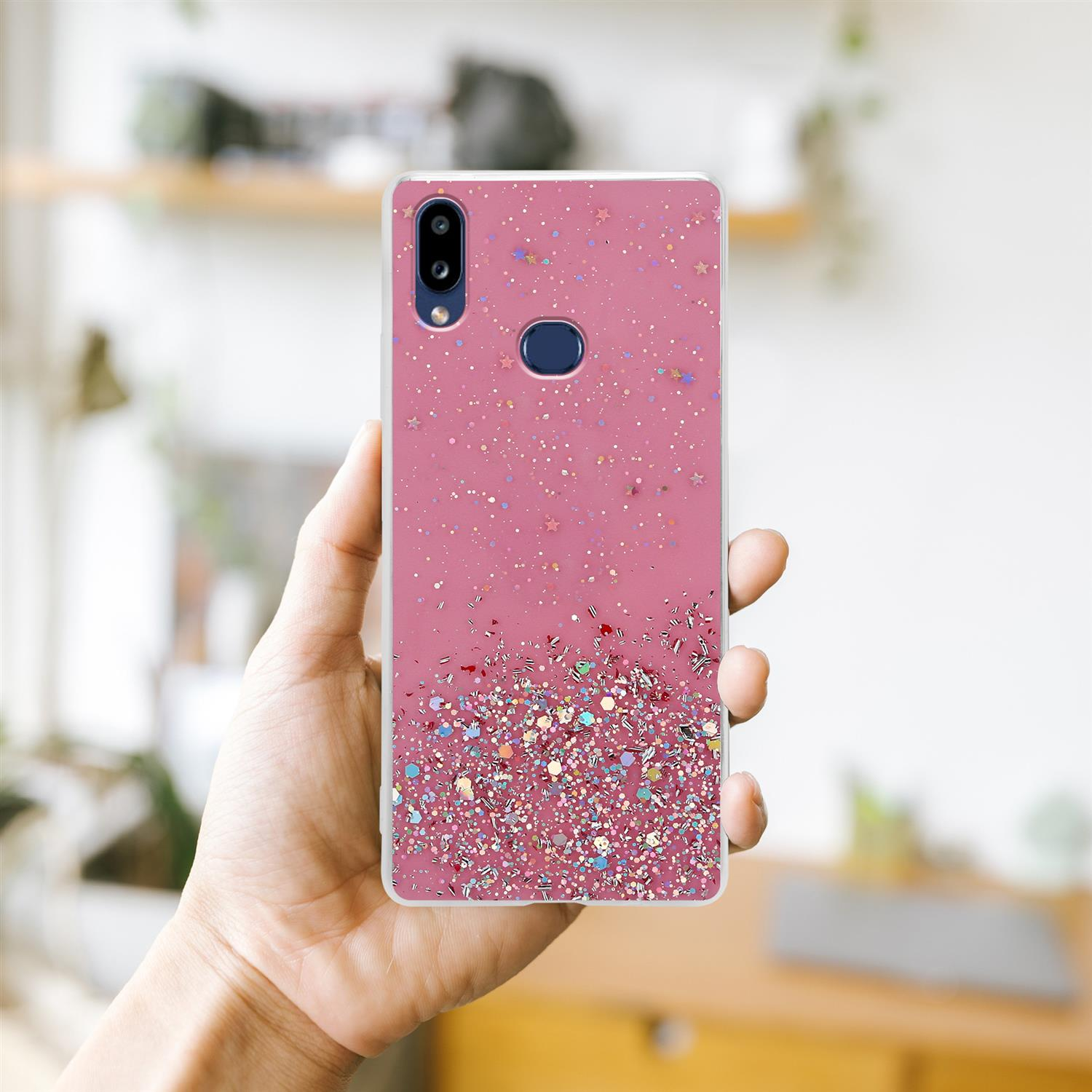 Eine Hand, die eine rosa Handyhülle mit einem Telefon darin hält. Die Handyhülle hat Glitzer.