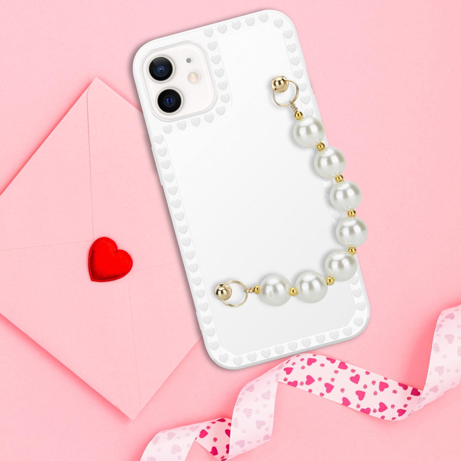 Weiße Handyhülle mit Perlenkette und rosa Hintergrund mit herzförmigem Siegel.
