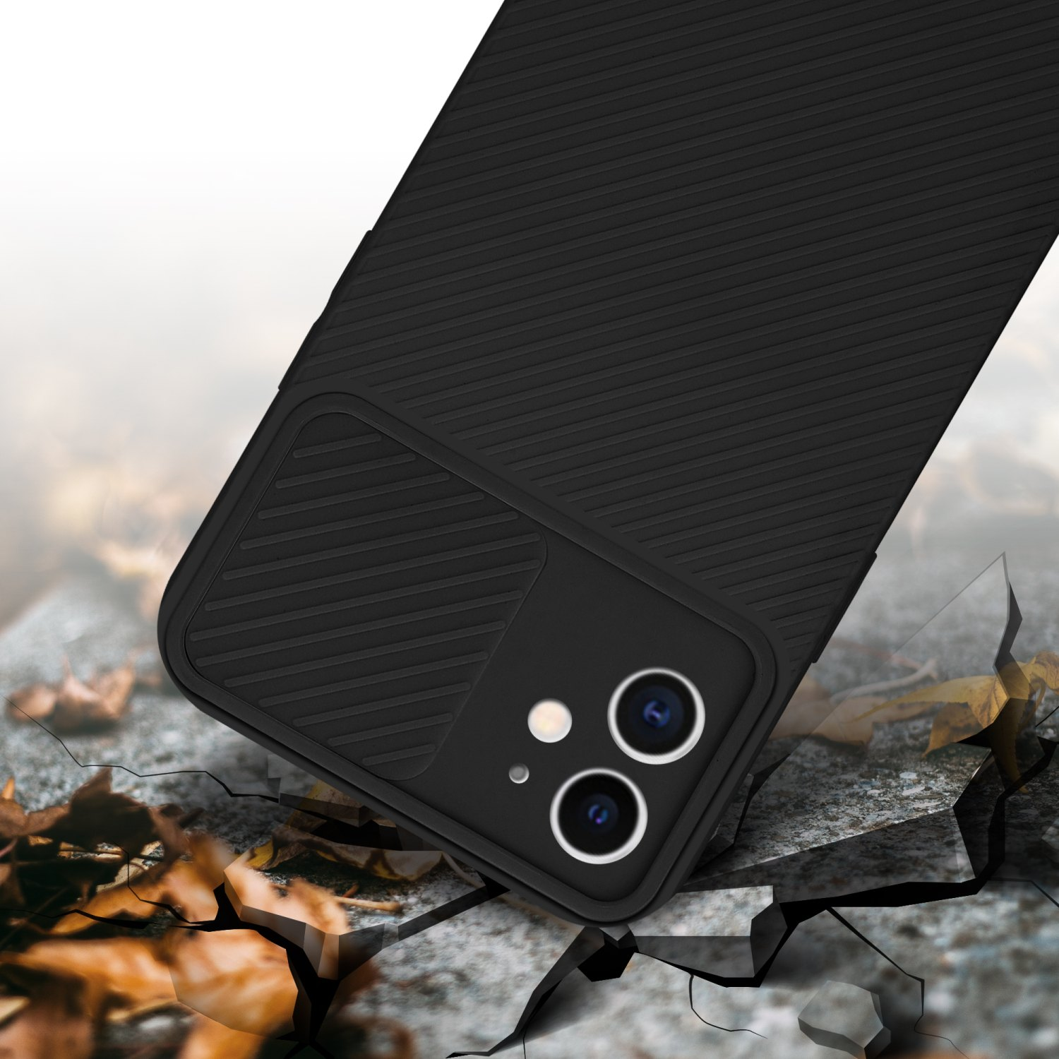 Custodia nera per telefono con fori per fotocamera, su cemento crepato con foglie.