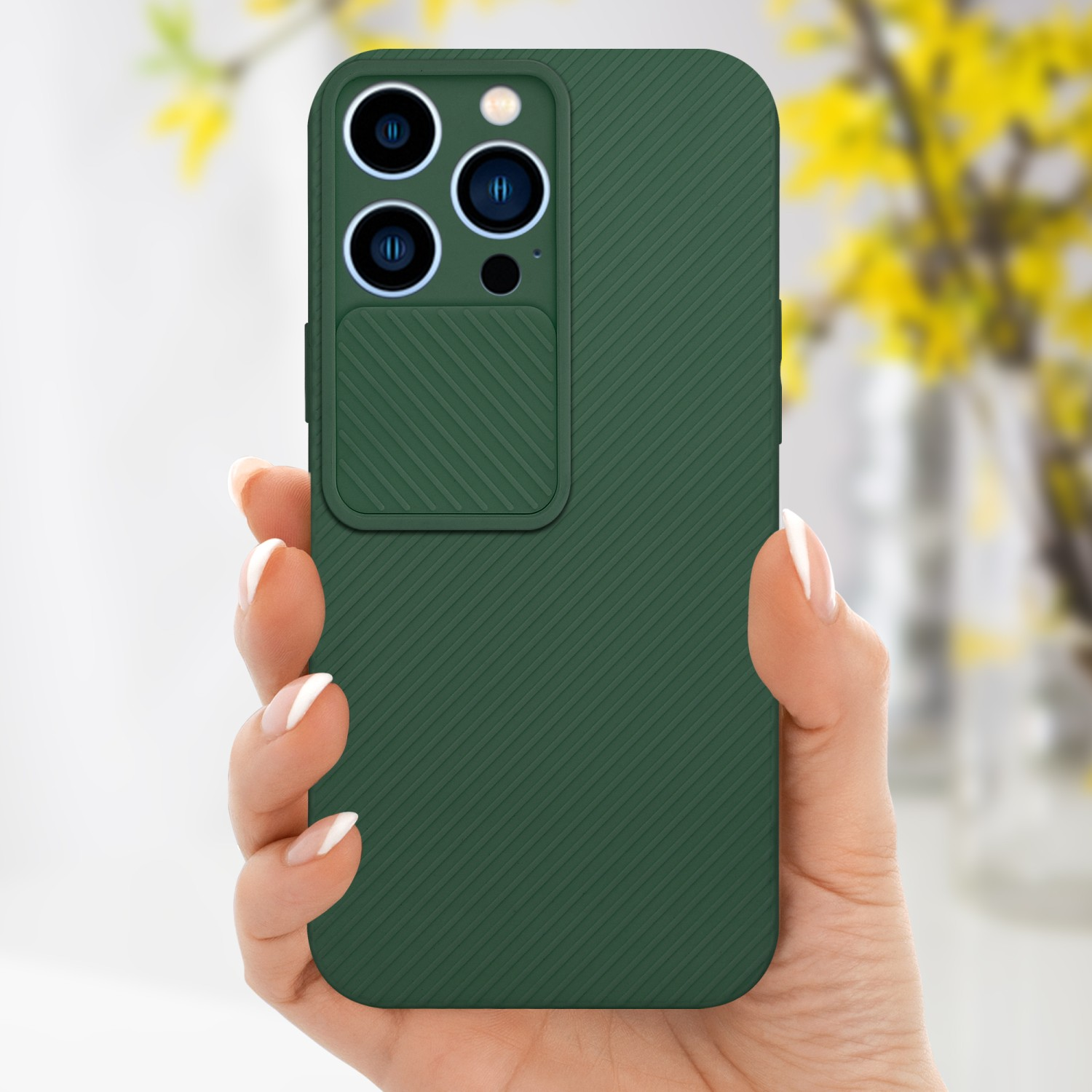 Mano che tiene una custodia verde per telefono. La custodia ha un ritaglio per la fotocamera e un design strutturato.