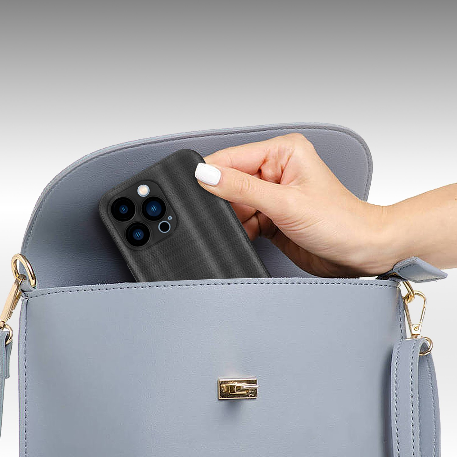 Una mano coloca un teléfono en un bolso azul claro. El teléfono tiene una funda negra.