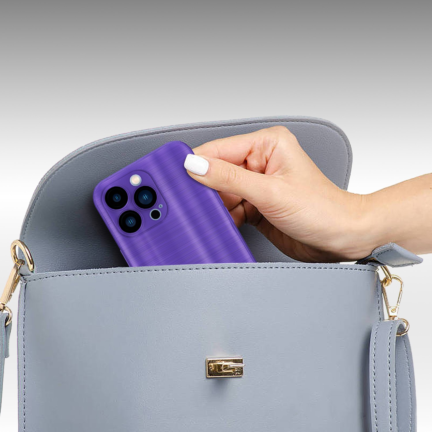 Una mano metiendo una funda morada para teléfono en un bolso azul claro. La funda tiene textura.