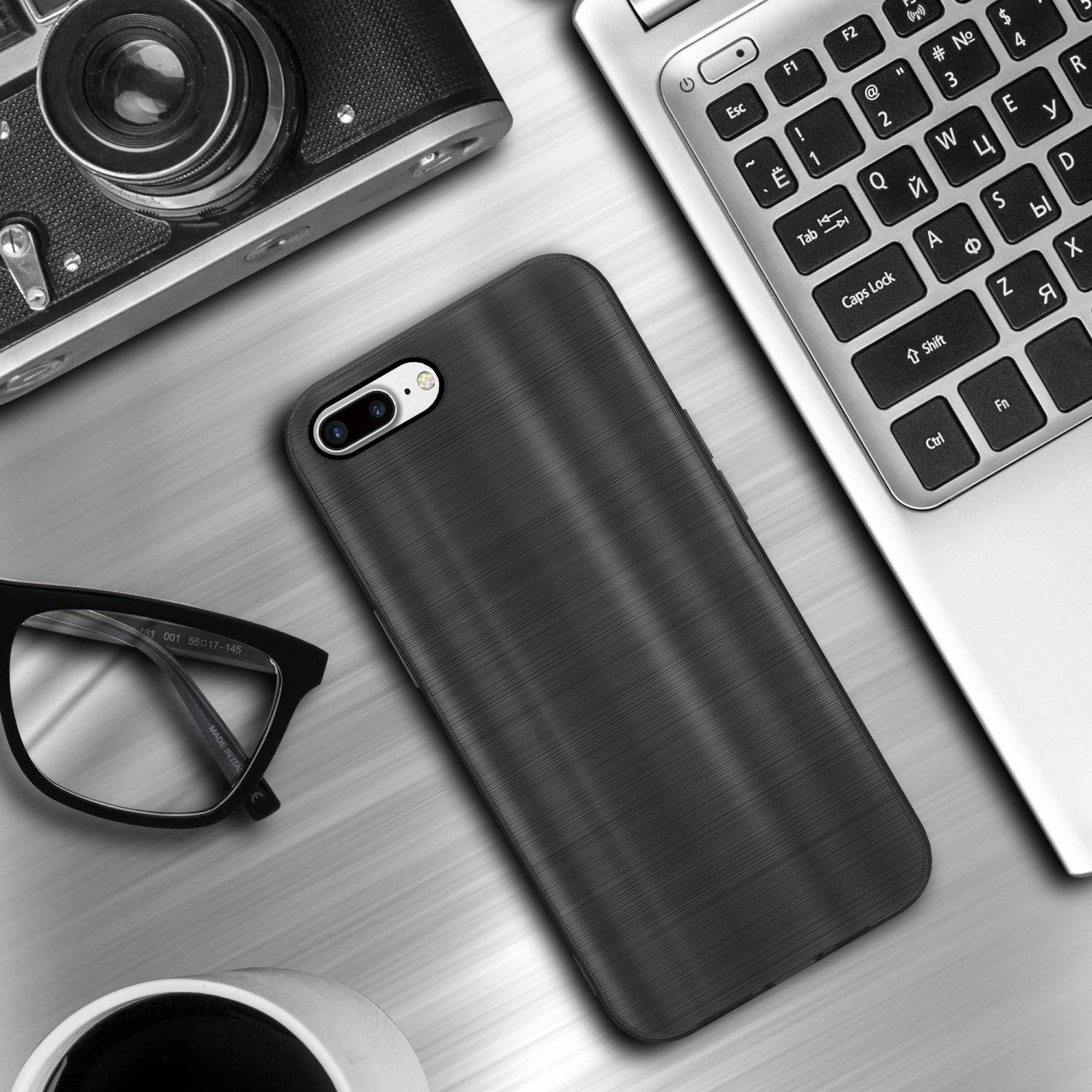 Schwarze Handyhülle auf Metalloberfläche. Neben Kamera, Brille, Laptop und Kaffee.