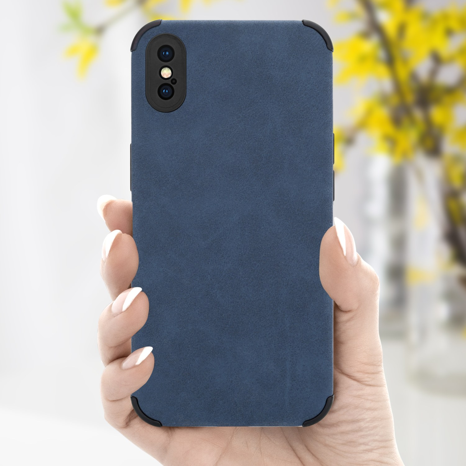 Eine Hand hält eine blaue Handyhülle mit schwarzen Rändern. Der Hintergrund zeigt ein verschwommenes gelbes Blumenarrangement.