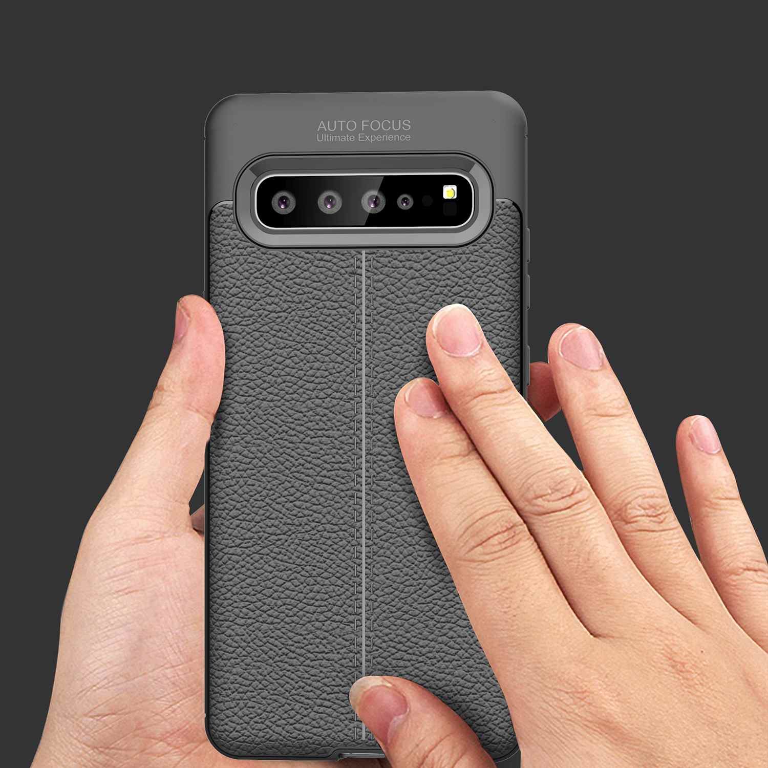 Hand berührt Telefon. Das Telefon hat eine graue Hülle. Der Hintergrund ist grau.