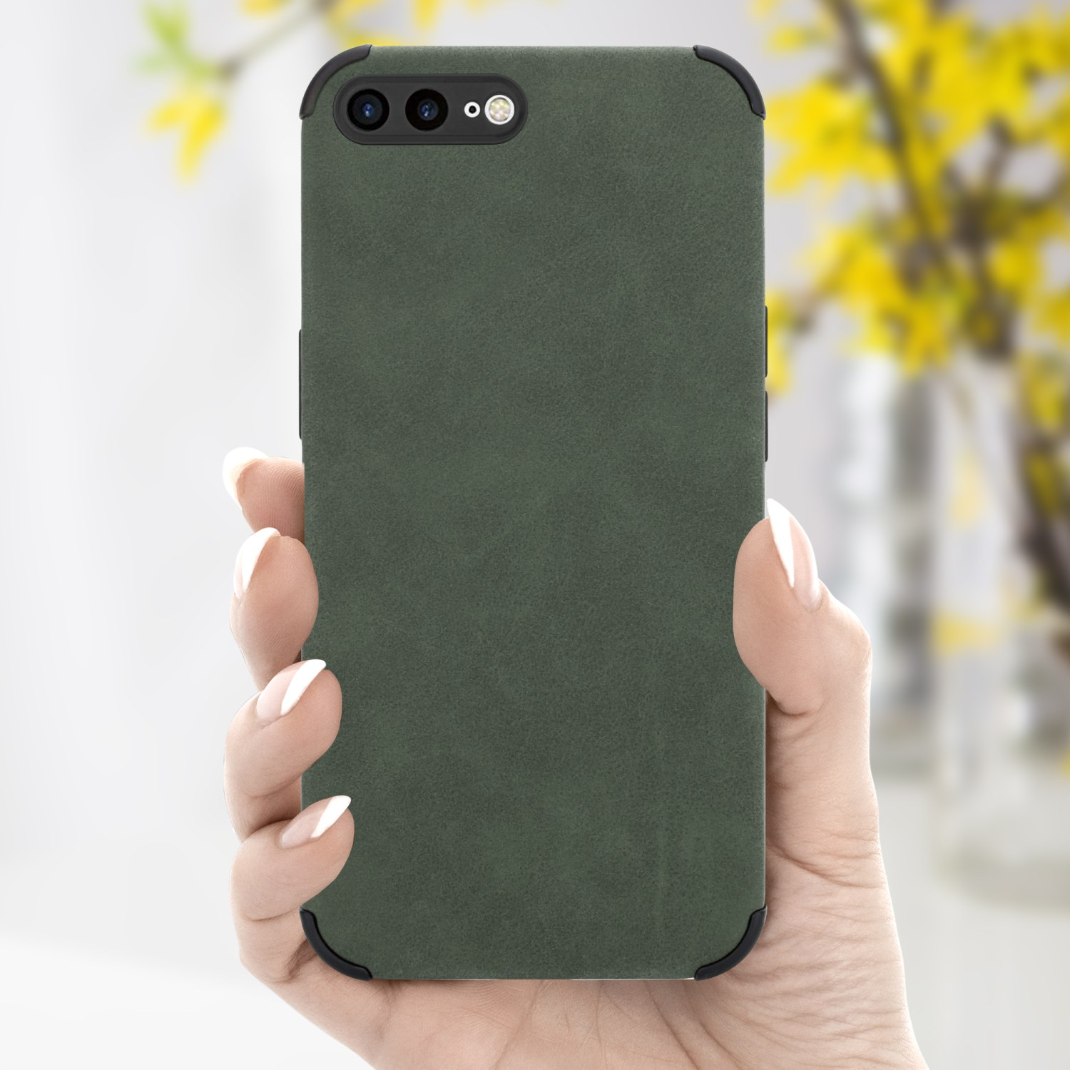 Hand hält ein grünes Telefon. Die Handyhülle ist grün, der Hintergrund unscharf mit gelben Blumen.