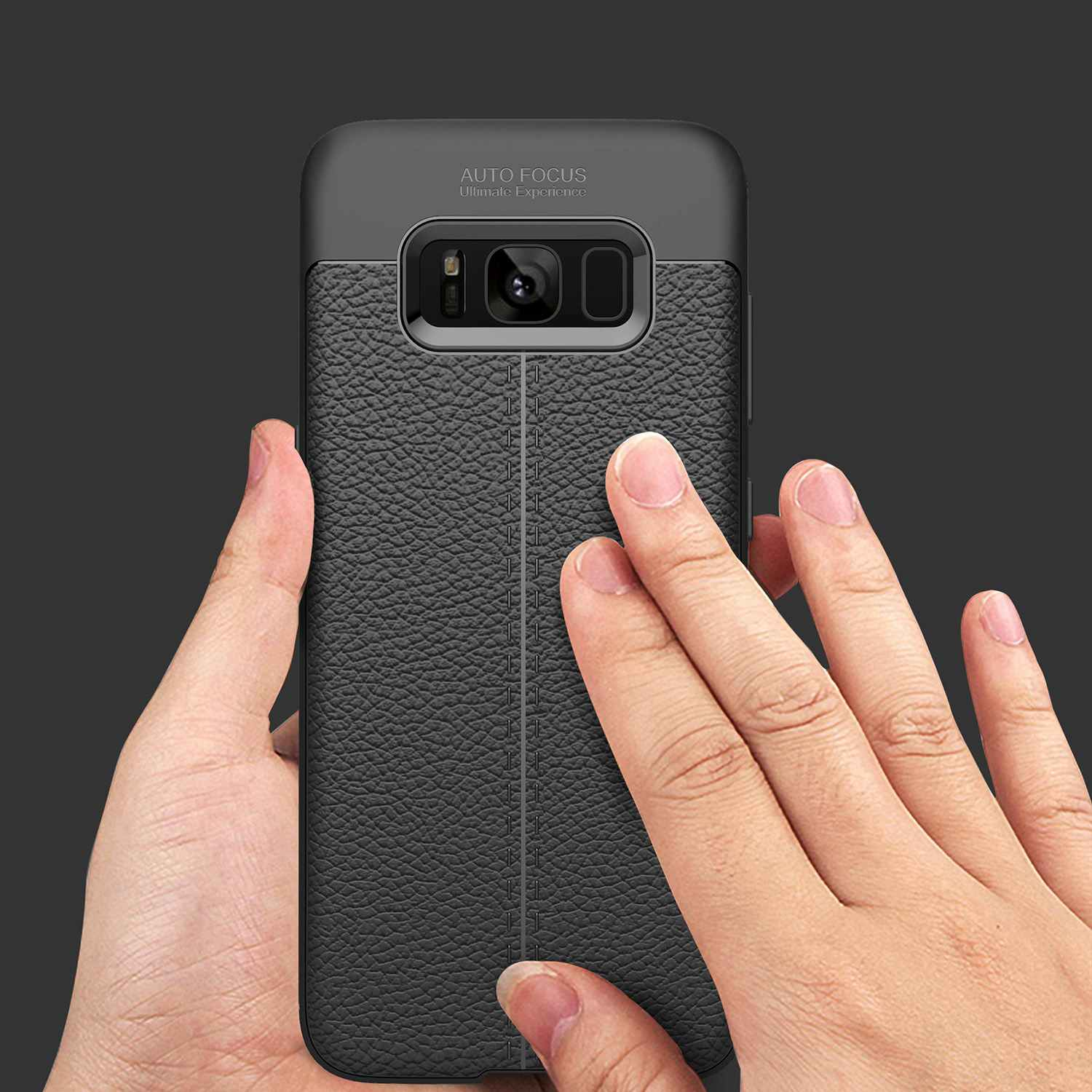 Hand, die eine schwarze Handyhülle mit Lederstruktur hält, dunkler Hintergrund.