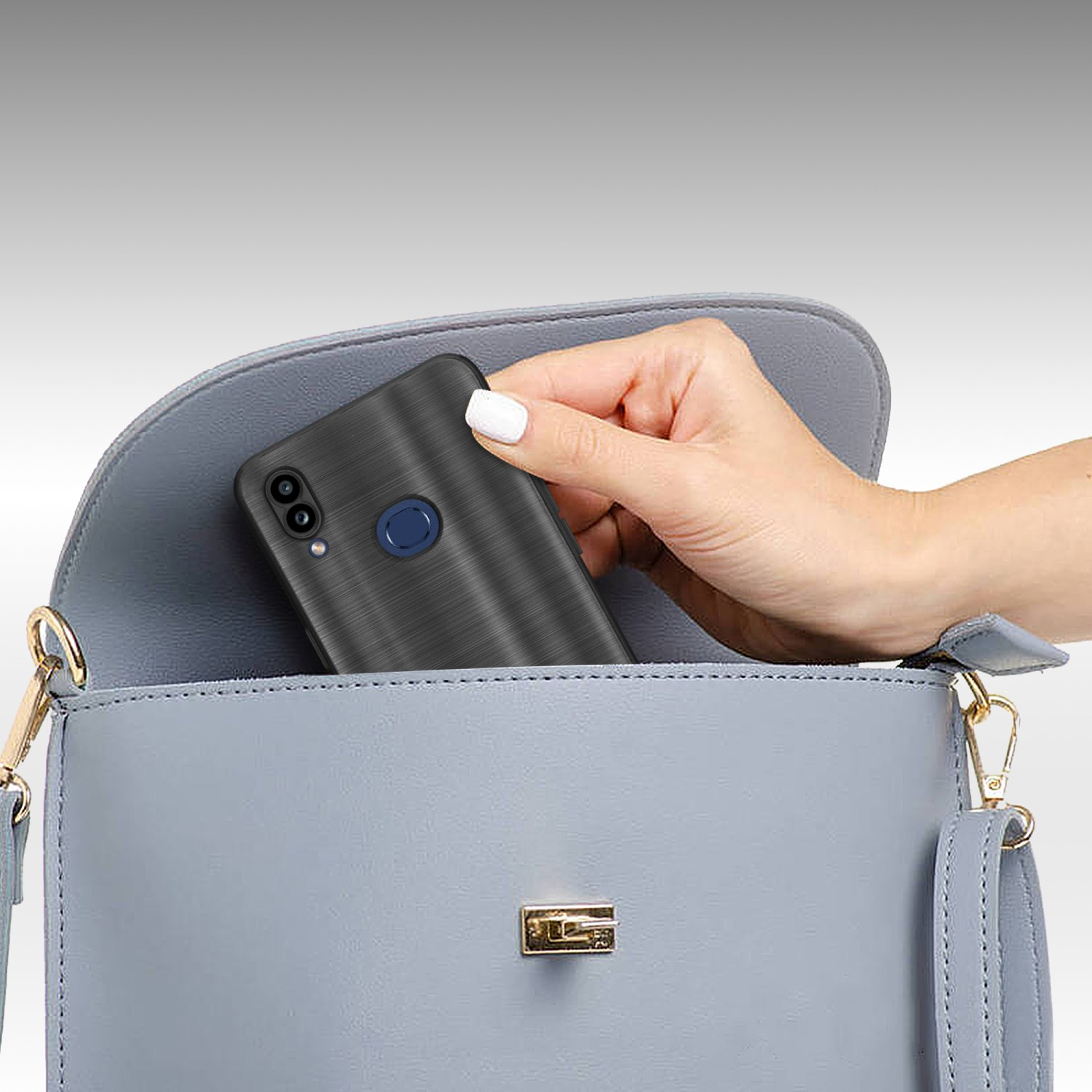 Una mano mette una custodia nera in una borsa azzurra. La custodia ha una superficie strutturata.