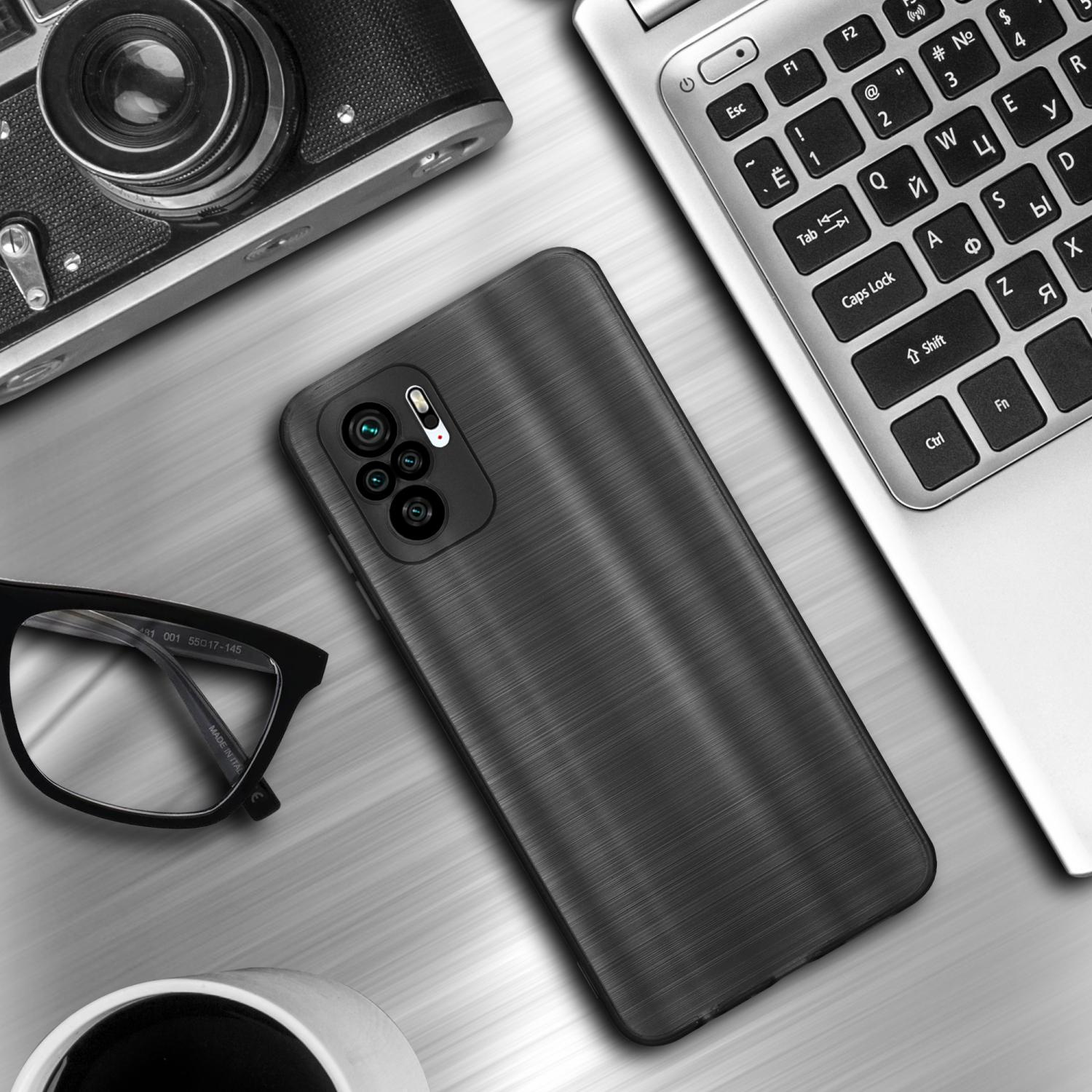 Una custodia per telefono nera su una scrivania con un laptop, occhiali e una fotocamera. La custodia ha una texture.