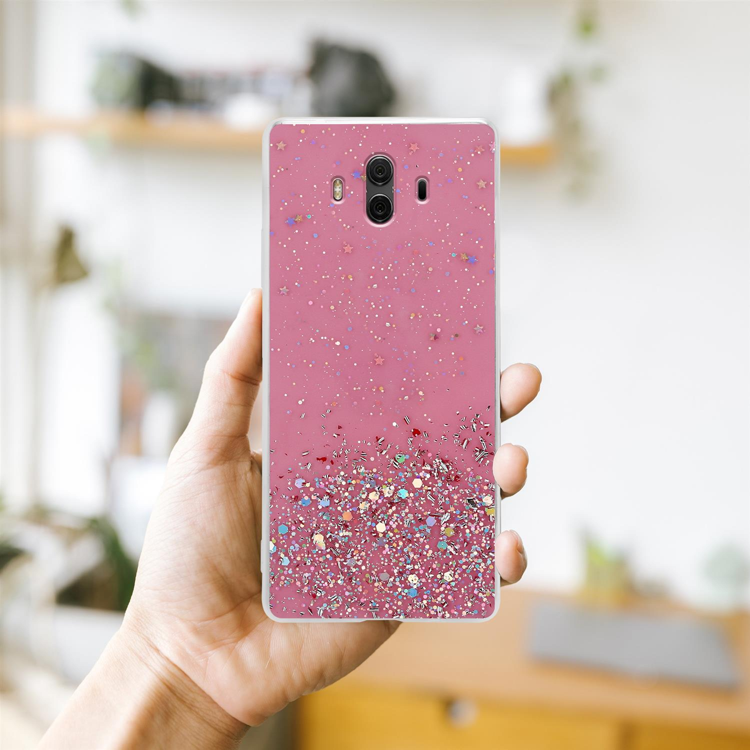 Eine Hand, die eine rosa Handyhülle mit Glitzer und Sternen hält. Der Hintergrund ist verschwommen.