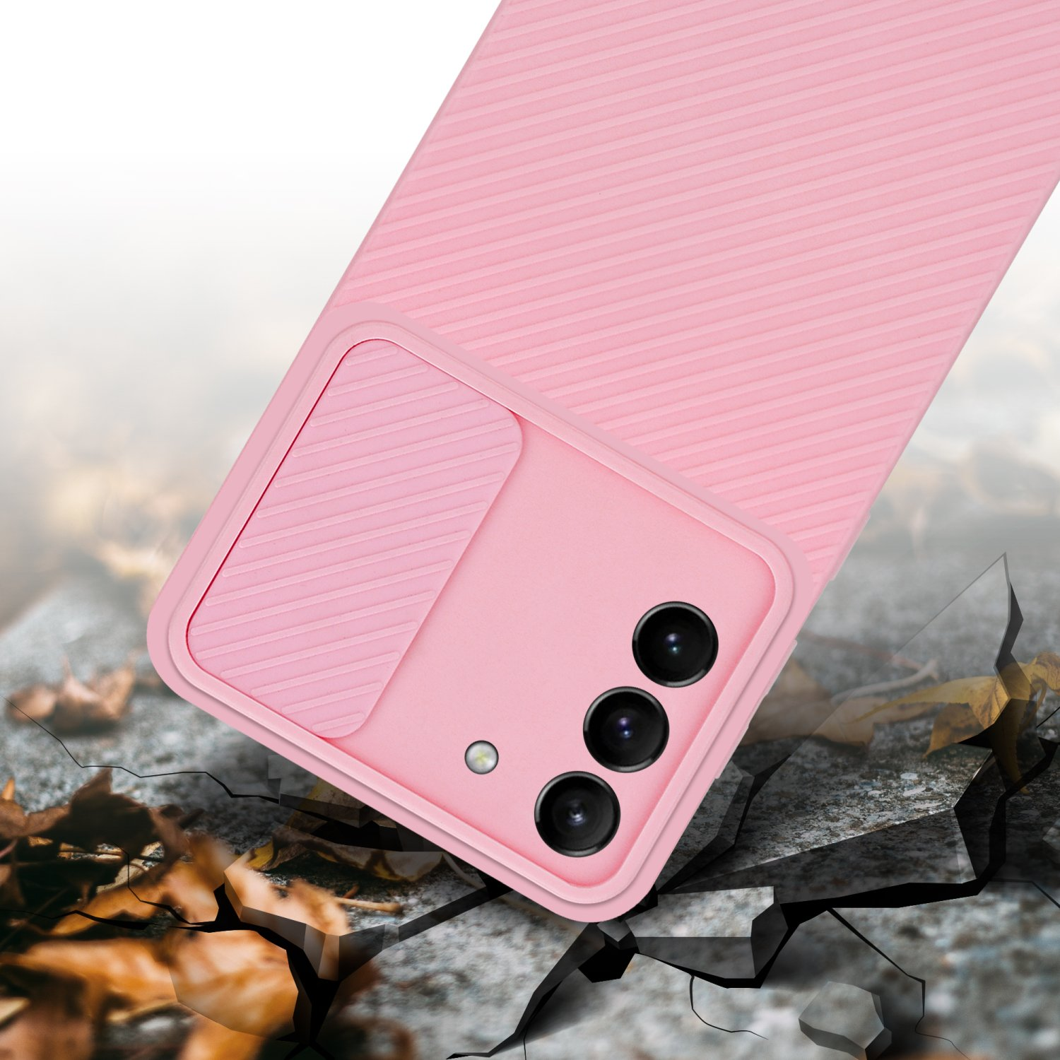 Custodia per telefono rosa con copertura della fotocamera, posizionata su una superficie incrinata con foglie.