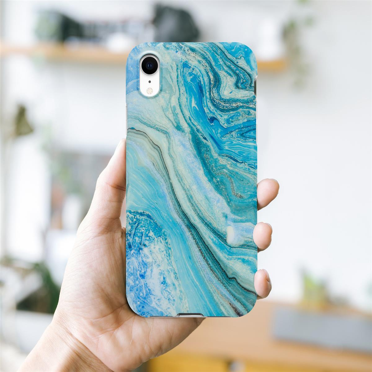 Mano che tiene un telefono con una custodia con motivo marmorizzato blu e bianco.