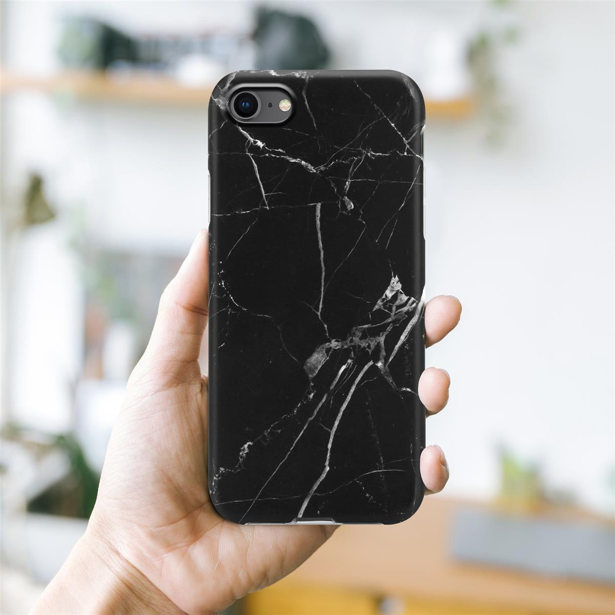 Custodia per telefono nera con design marmorizzato. Mano che tiene il telefono su sfondo sfocato.