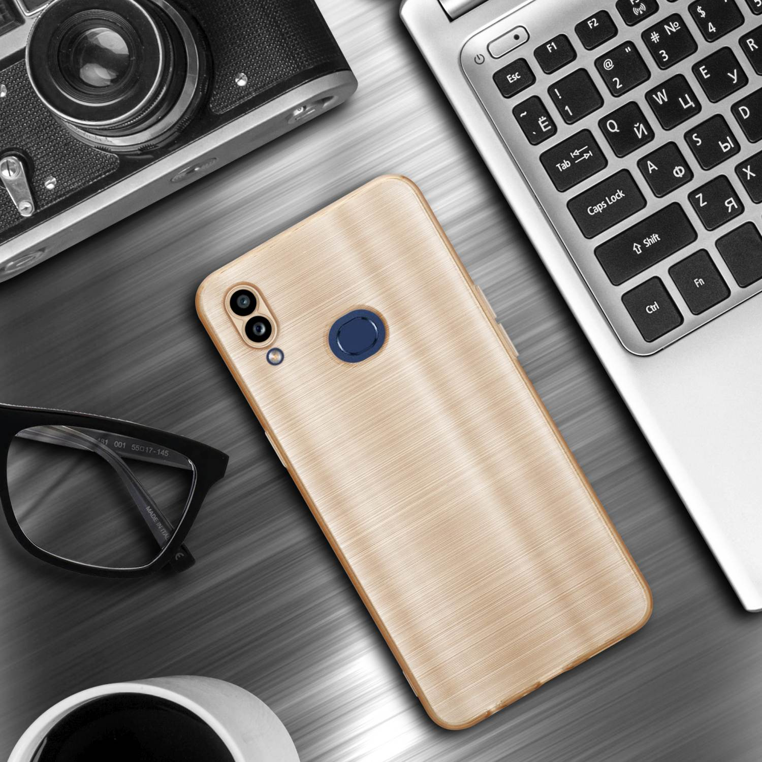 Una custodia dorata per telefono su una scrivania con un laptop, occhiali e una fotocamera. Struttura in legno.