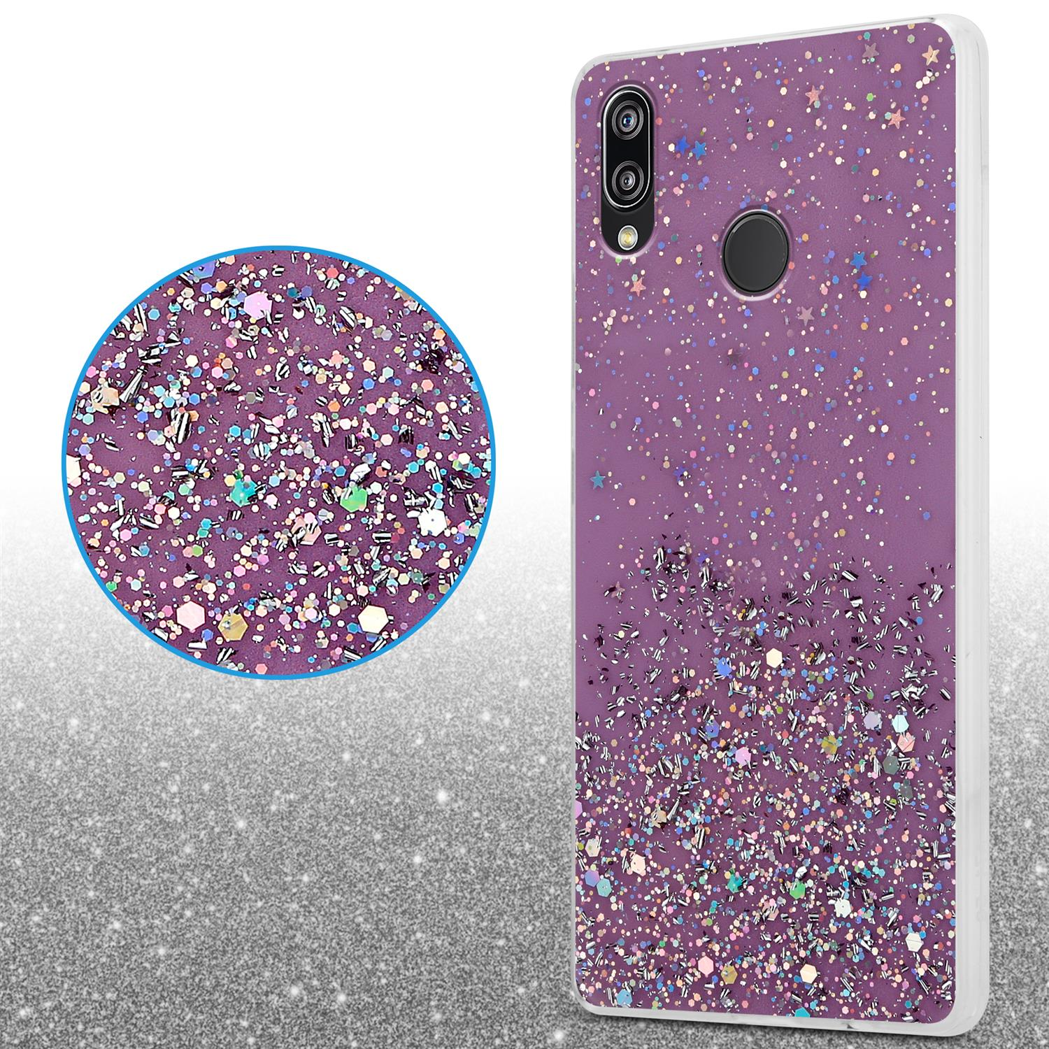 Lila Handyhülle mit Glitzer. Das Telefon liegt auf weißer Oberfläche. Der Hintergrund ist unscharf.