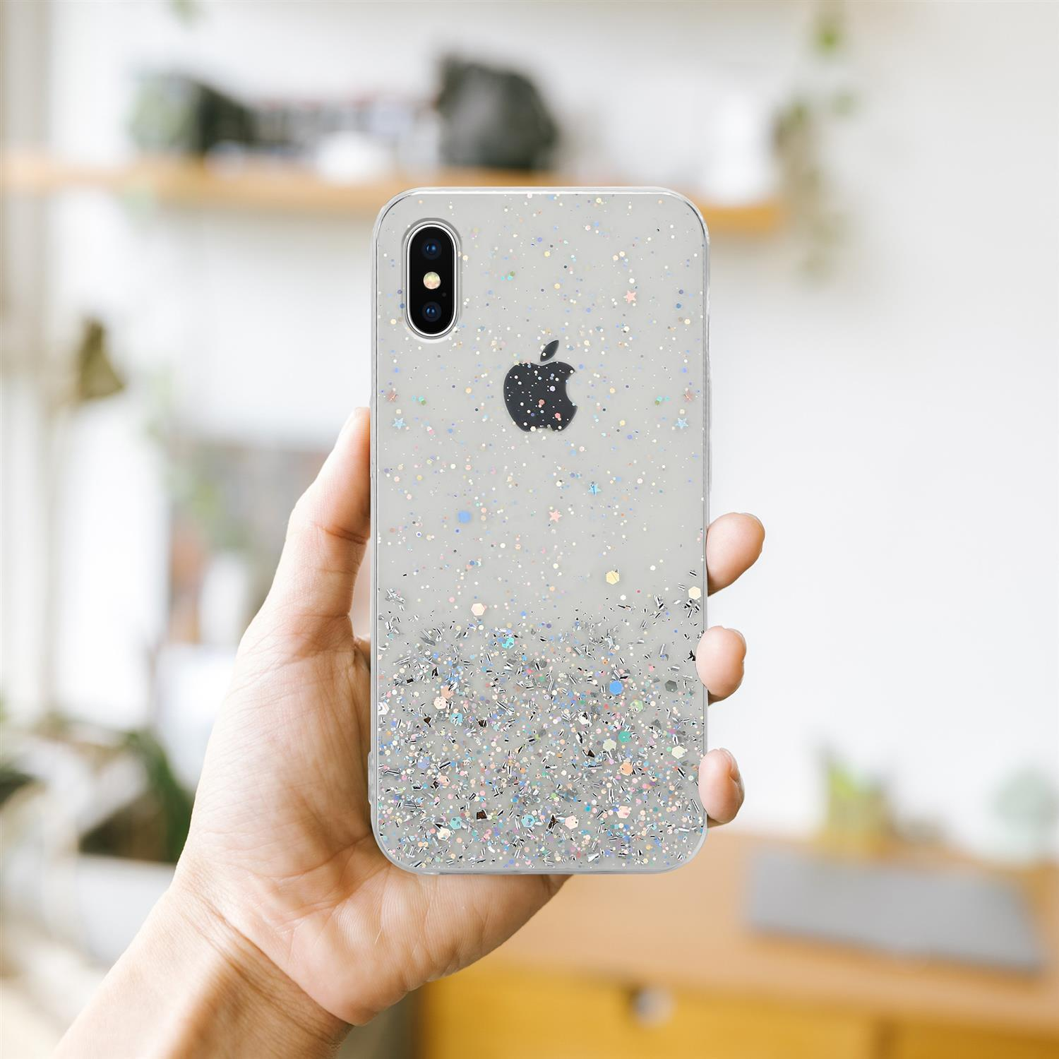 Hand hält ein Telefon mit einer durchsichtigen Hülle, die mit Glitzer bedeckt ist. Apple-Logo sichtbar.