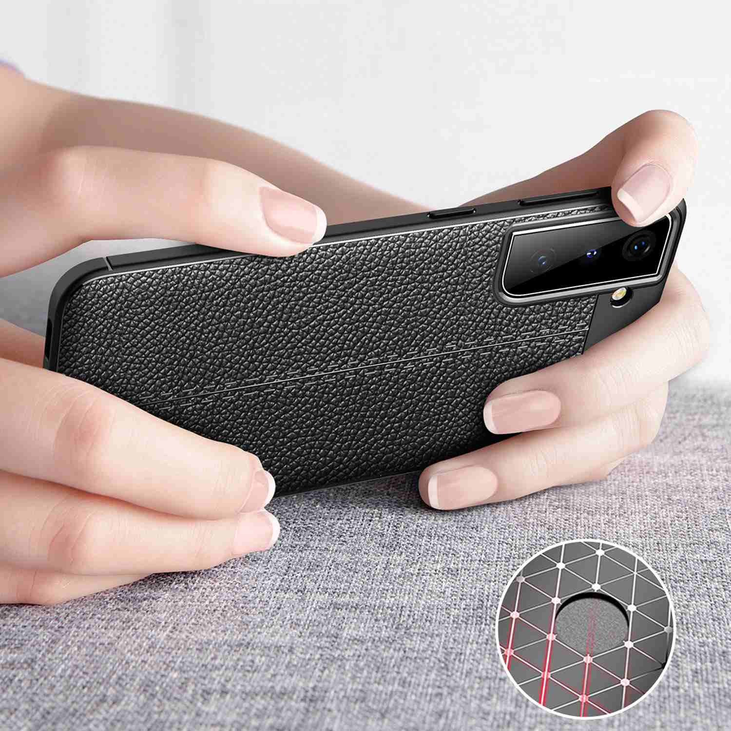 Una persona tiene in mano una custodia nera con una texture in pelle. La fotocamera del telefono è visibile.