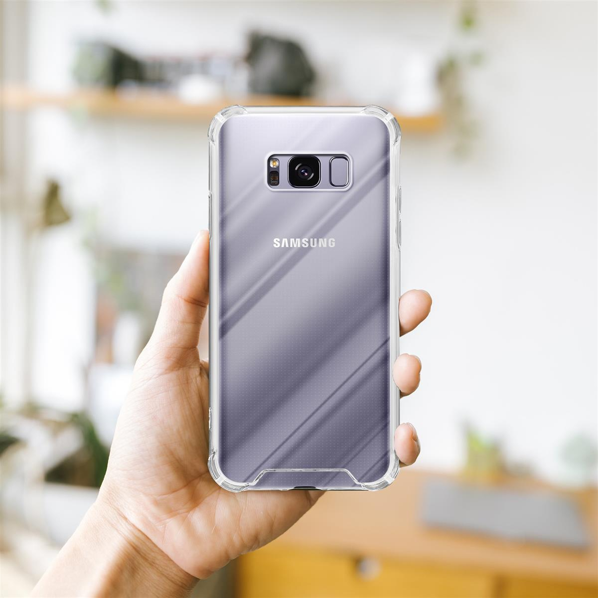 Mano che tiene una custodia trasparente su un telefono Samsung. Sfondo sfocato.