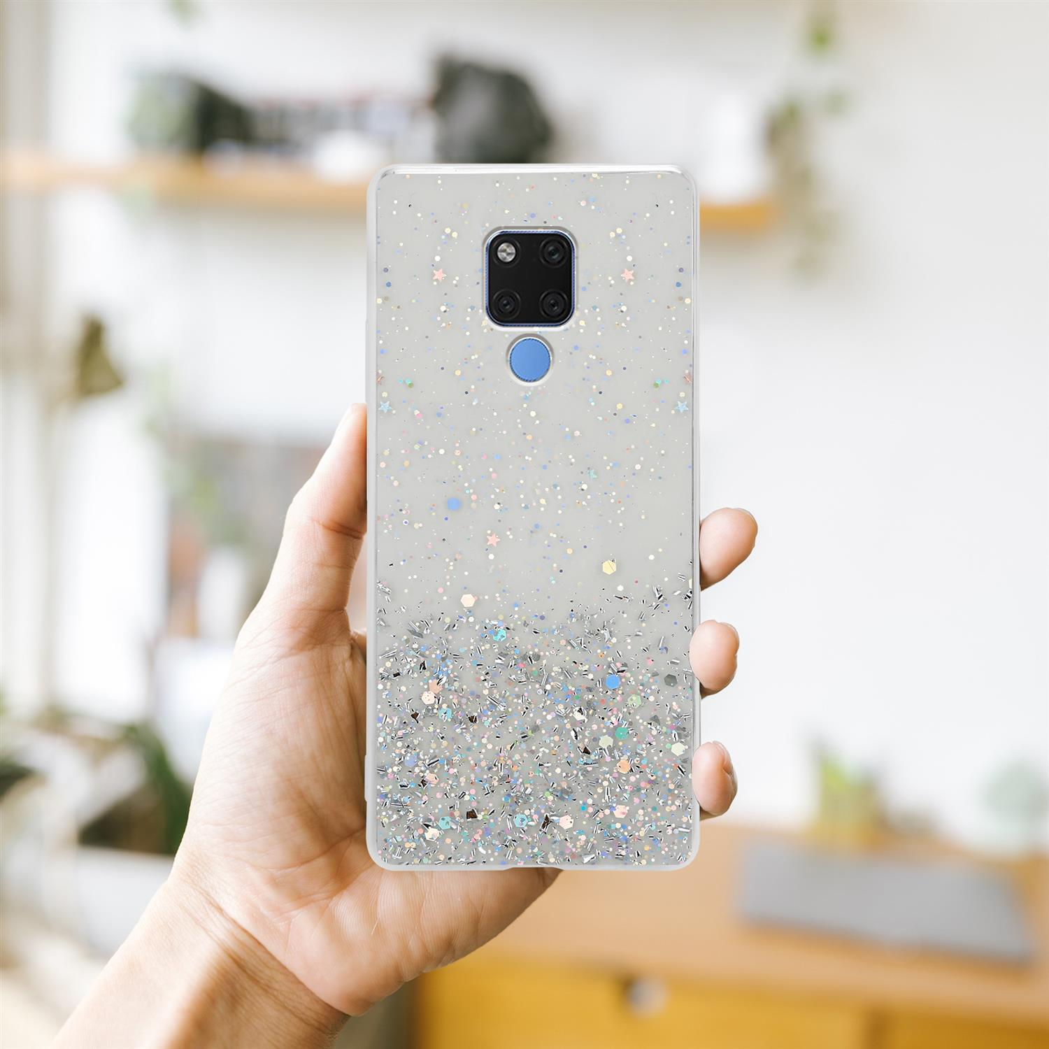 Hand, die eine Handyhülle mit Glitzer hält. Das Telefon ist silber mit Glitzer.