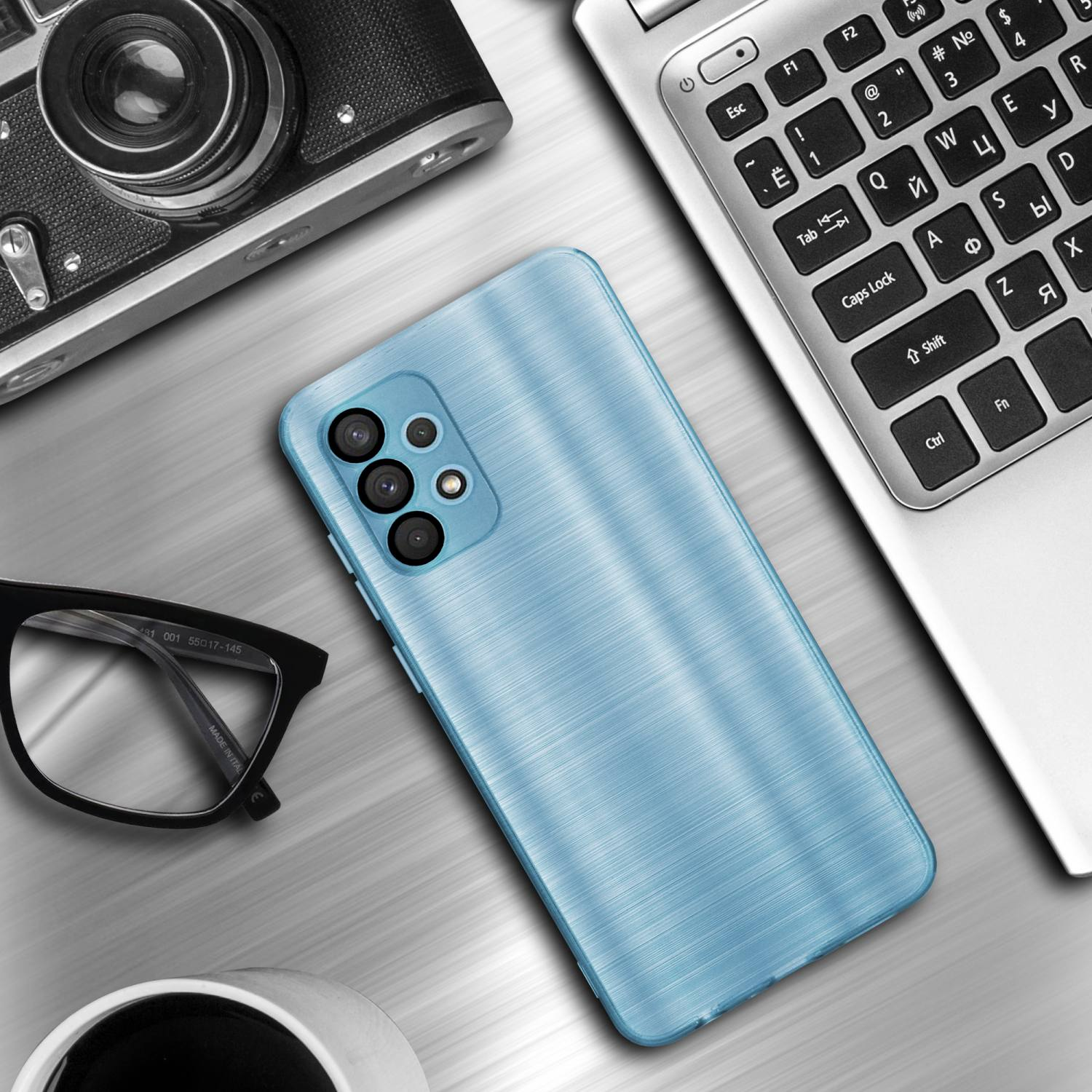 Custodia blu per telefono su tavolo con fotocamera, occhiali, laptop e tazza di caffè.