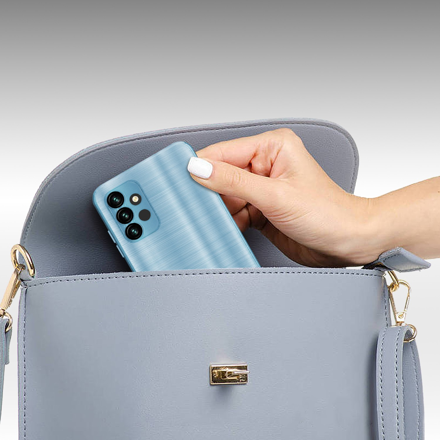 Una mano che mette un telefono blu con più fotocamere in una borsa grigia. Sfondo sfocato.