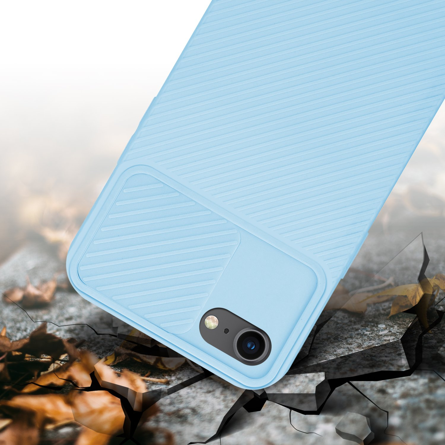 Blaue Handyhülle. Telefon teilweise sichtbar. Boden mit Rissen und Blättern, unscharfer Hintergrund.