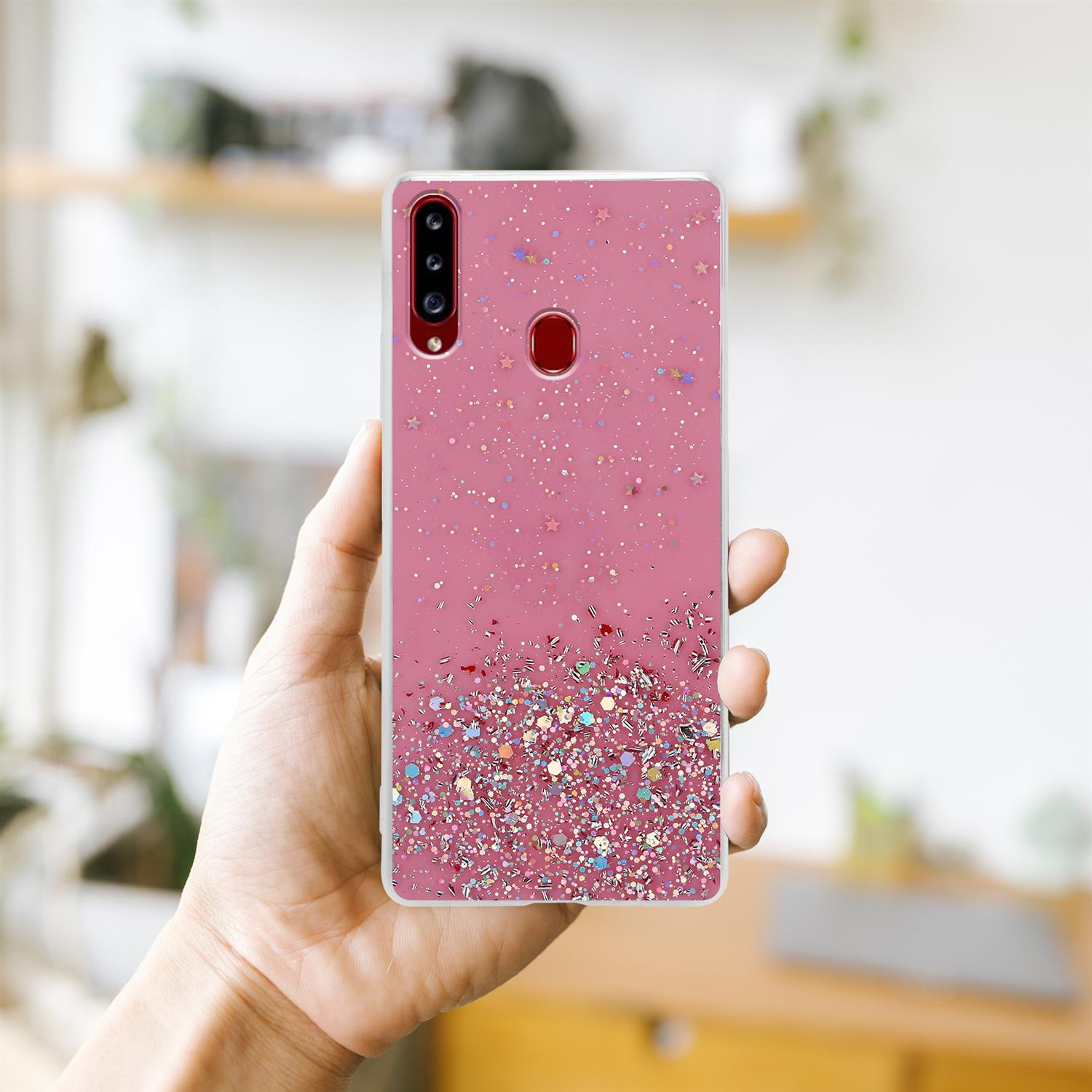 Pinke Handyhülle mit Glitzer. Eine Hand hält das Telefon. Der Hintergrund ist verschwommen.